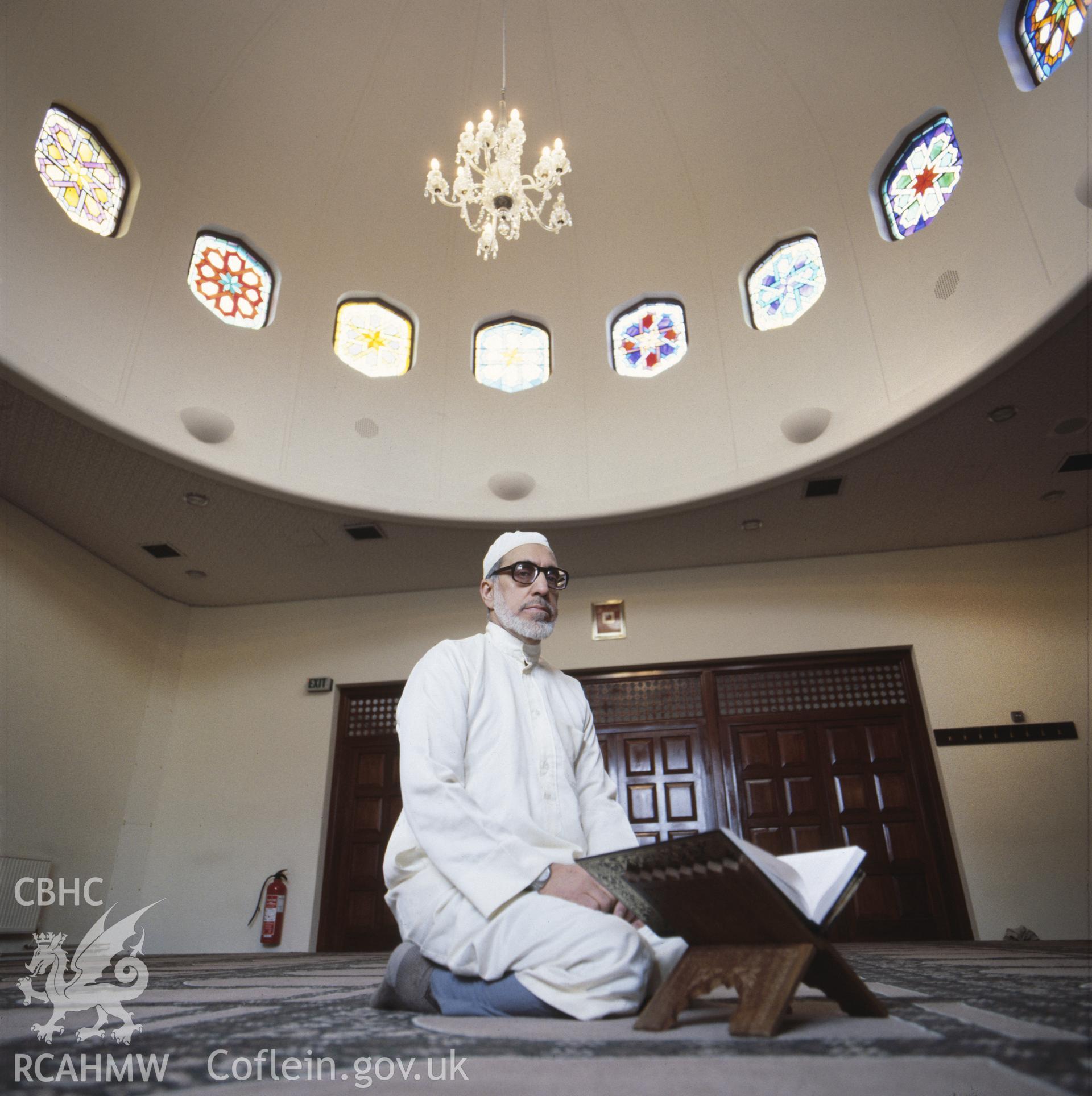 1 colour transparency showing interior view of the Islamic Centre, Butetown, Cardiff with Iman; collated by the former Central Office of Information.