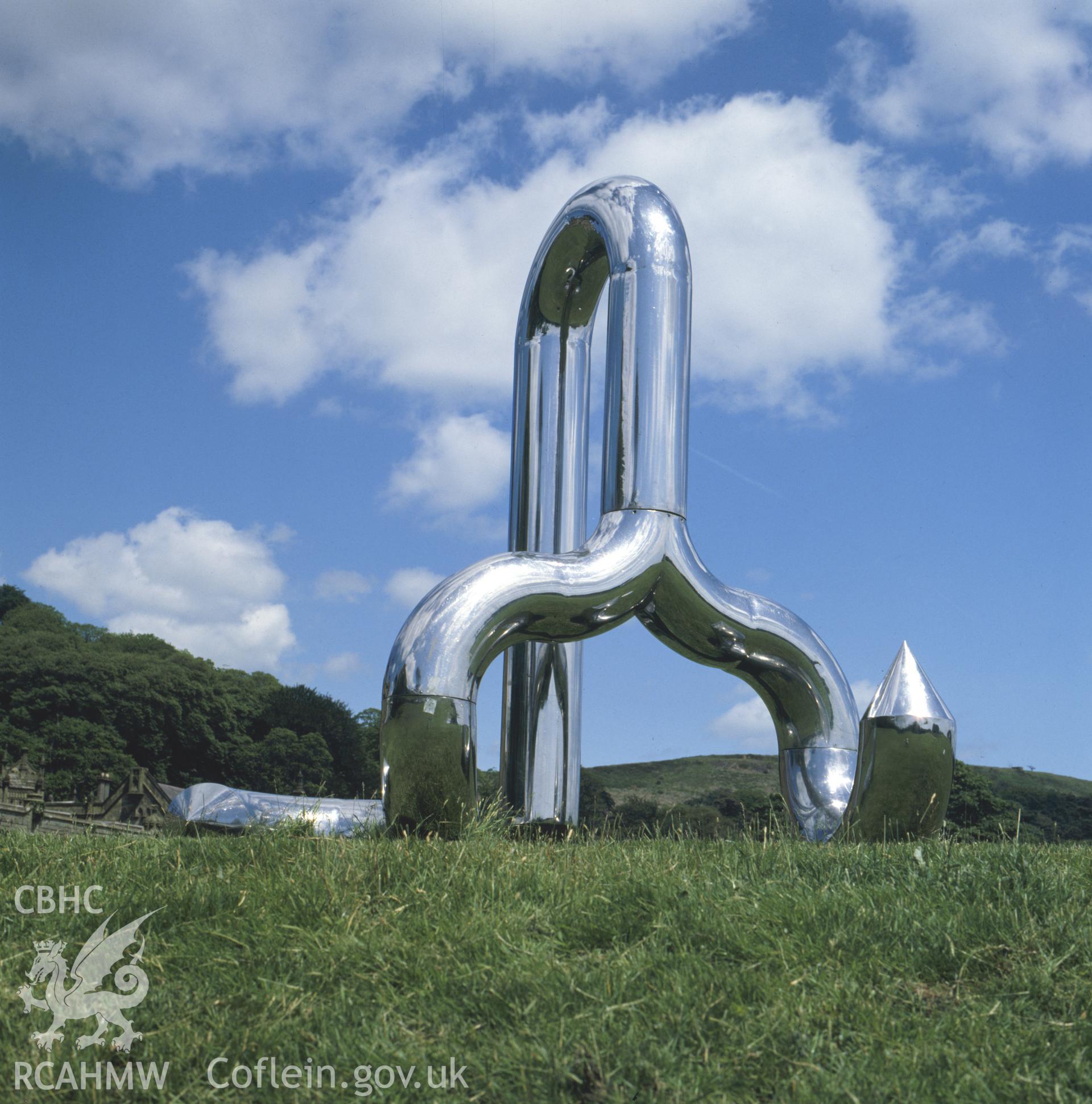 1 colour transparency showing view of steel abstract sculpture enitled: 'Quillion' by Robert Pye, situated at Margam sculpture park; collated by the former Central Office of Information.