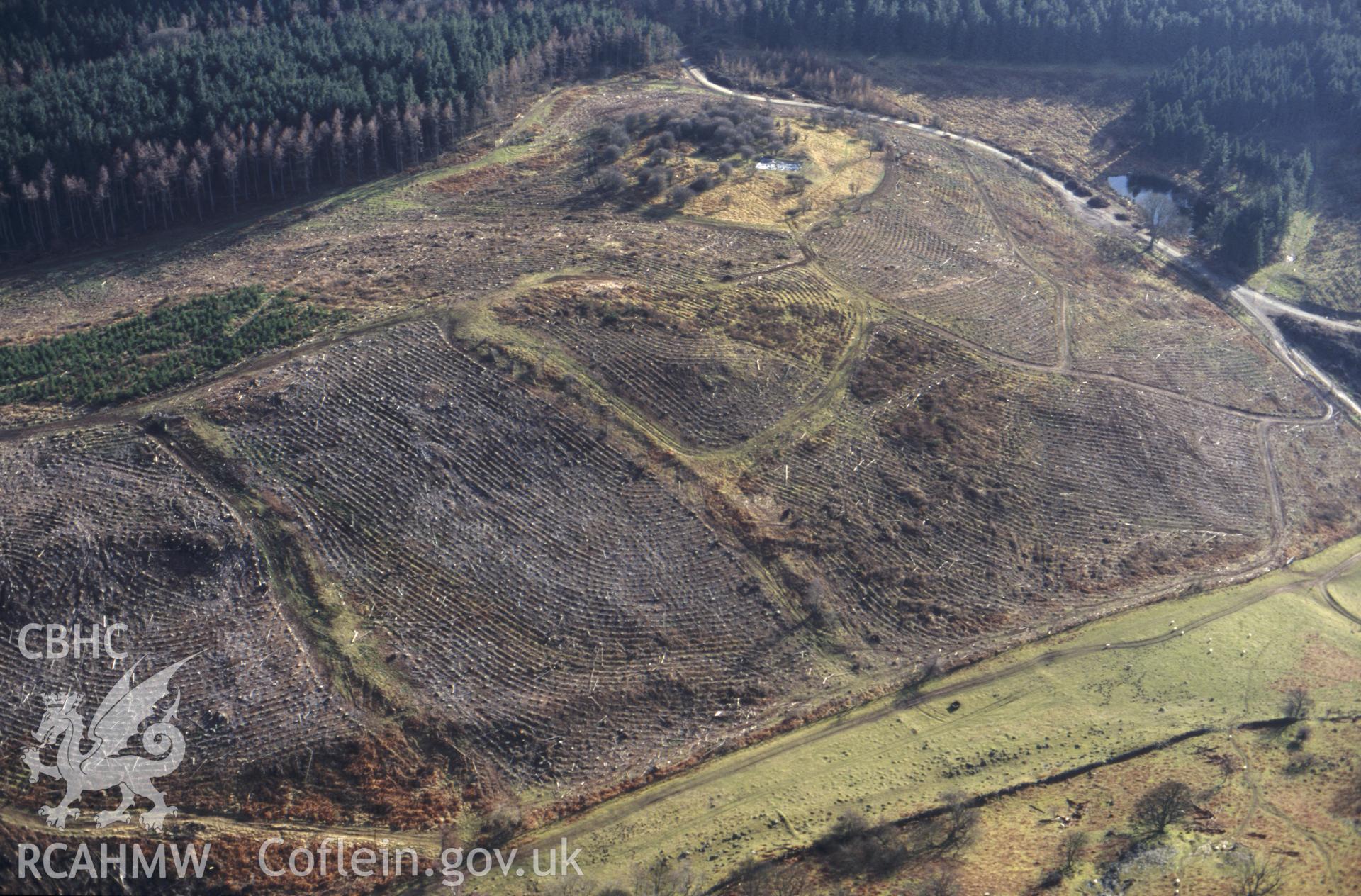 RCAHMW colour slide oblique aerial photograph of Newpieces Enclosure, Breiddin Hill, Bausley With Criggion, taken by C.R.Musson on the 14/02/1997