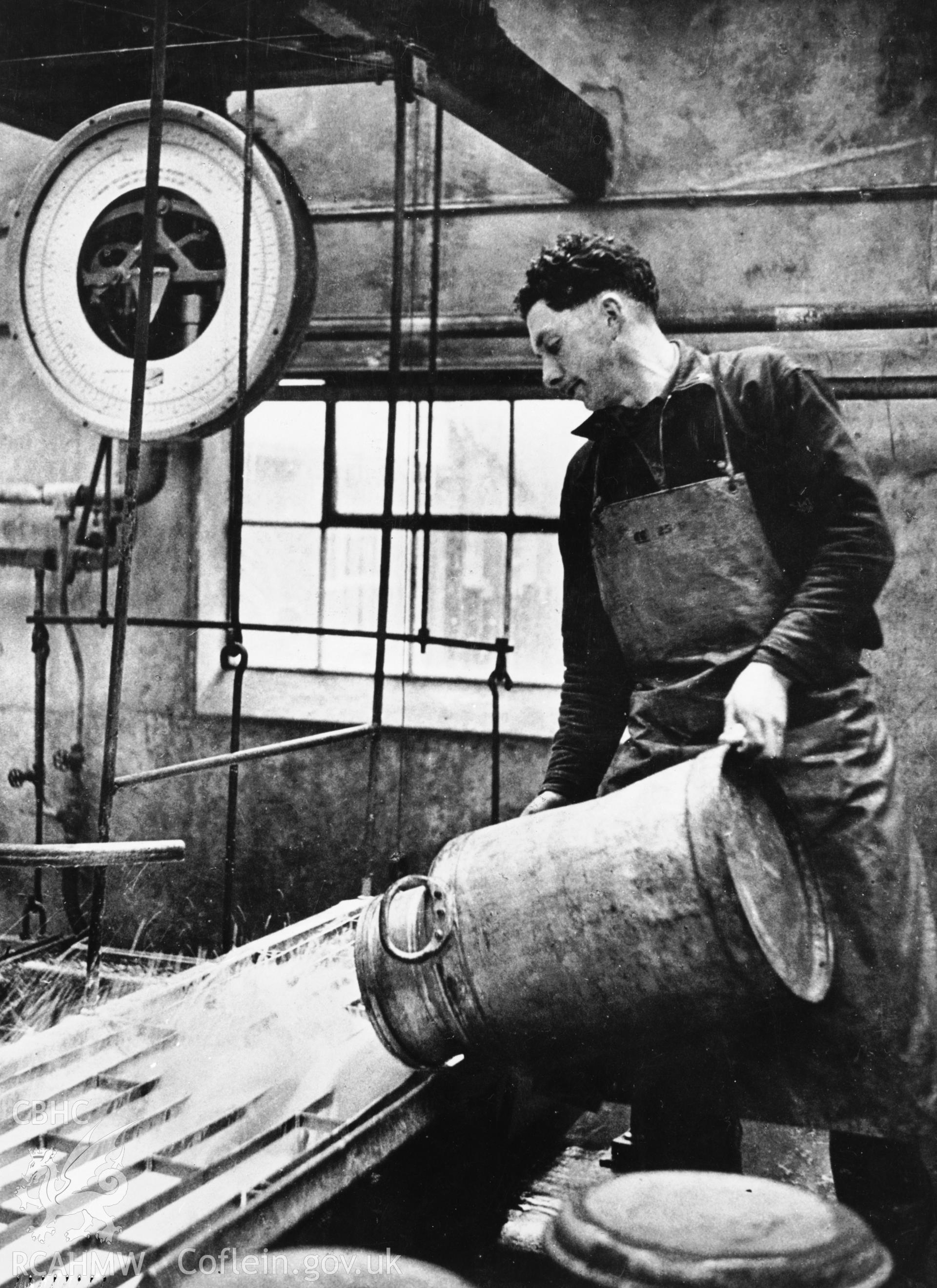 Copy of a pre-1950 photo showing the transfer of milk from churn