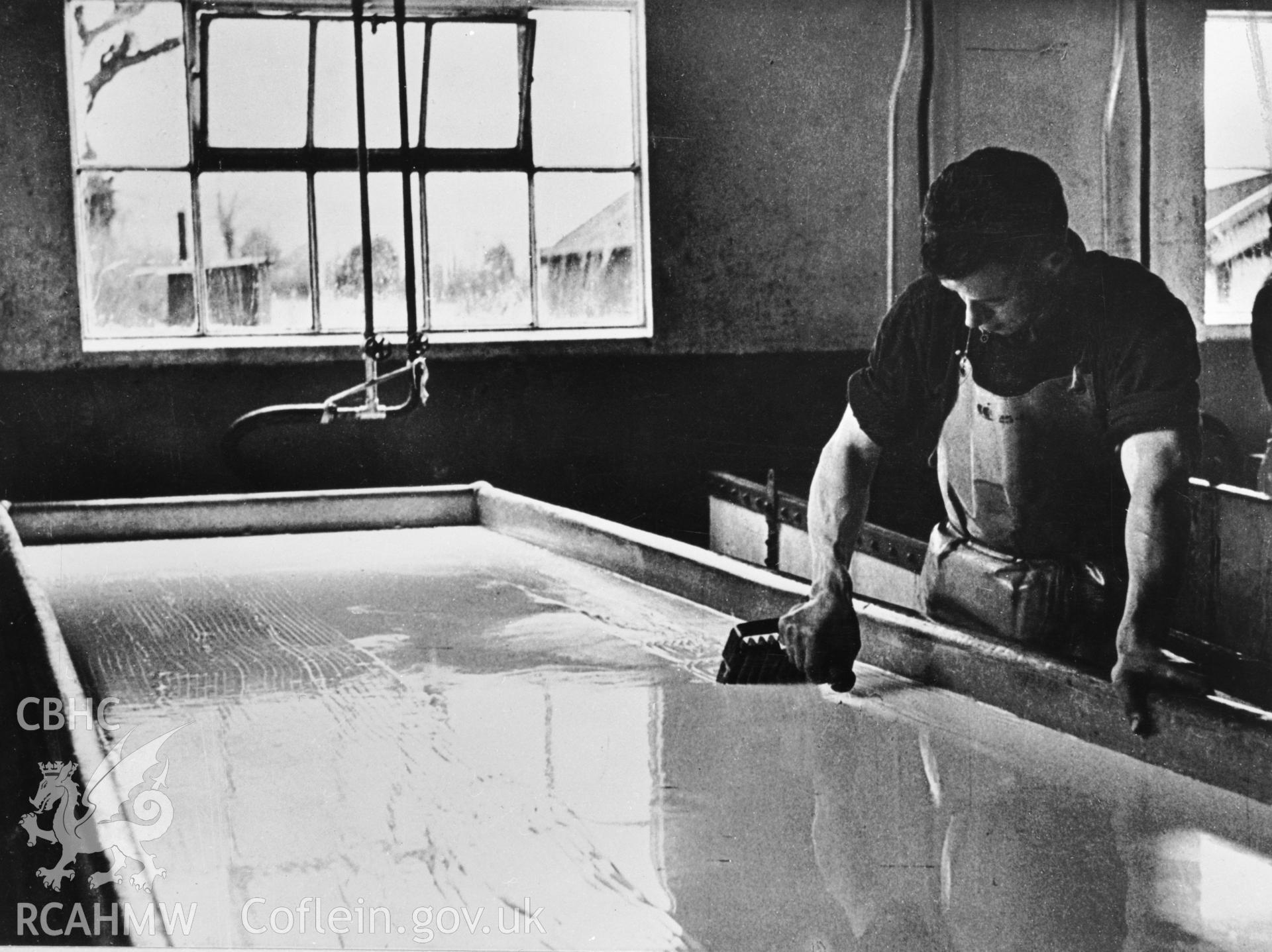 Copy of a pre-1950 photo showing early stages of cheese production