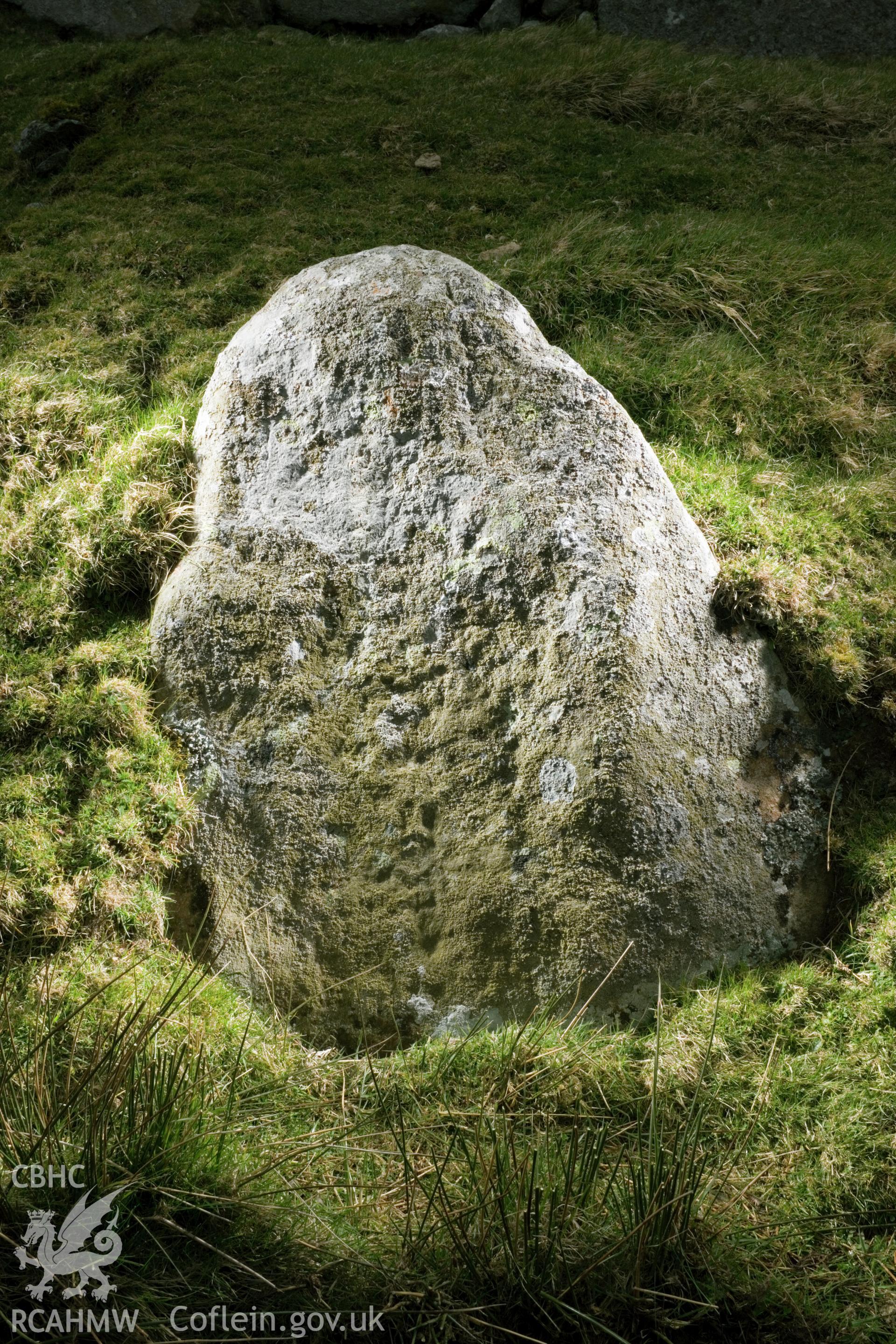 Cross carved stone (visible in middle of face, just below centre; taking up a third of the face).