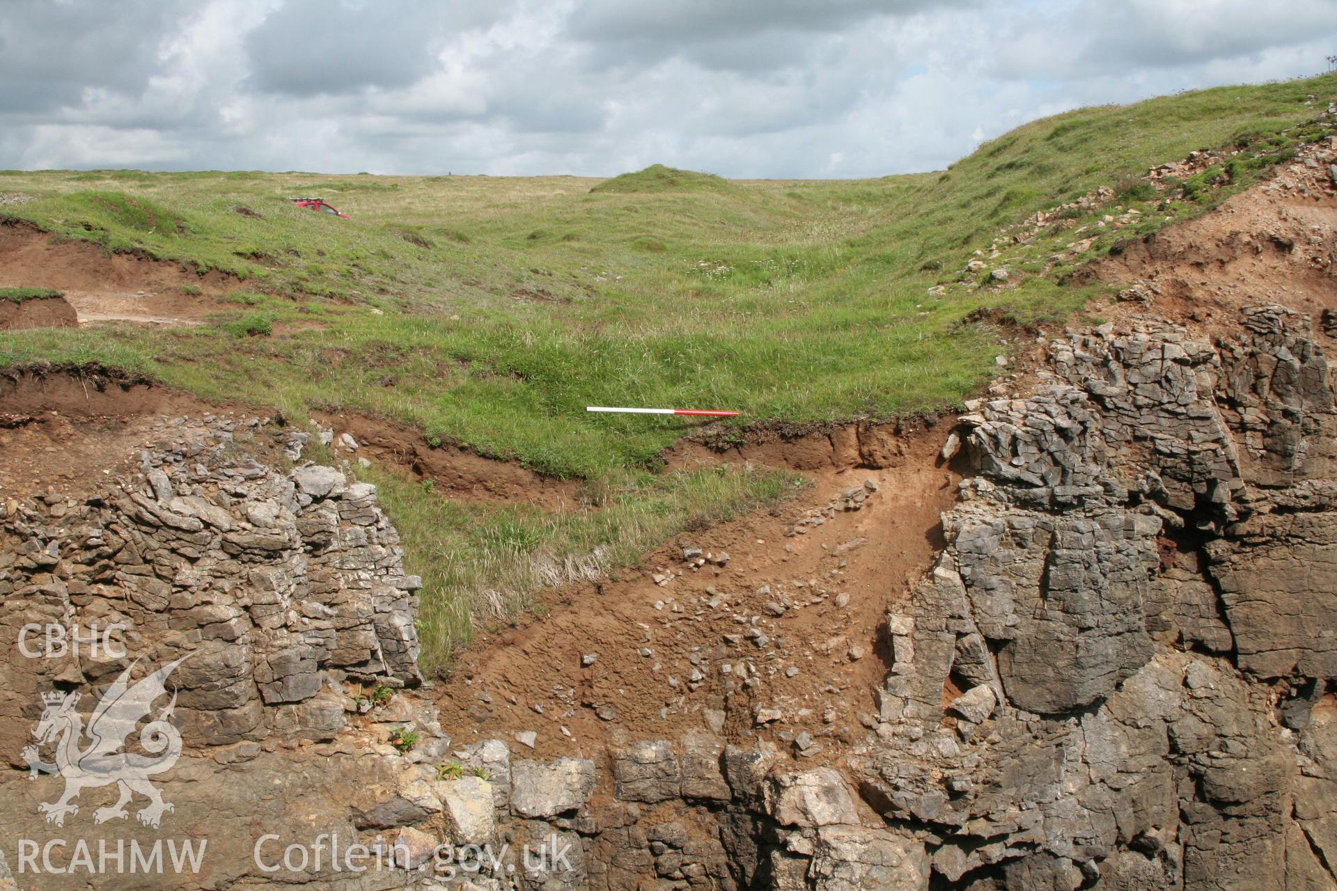 Eroded section showing the rock cut outer rampart ditch of the defences to the west of the fort entrance.