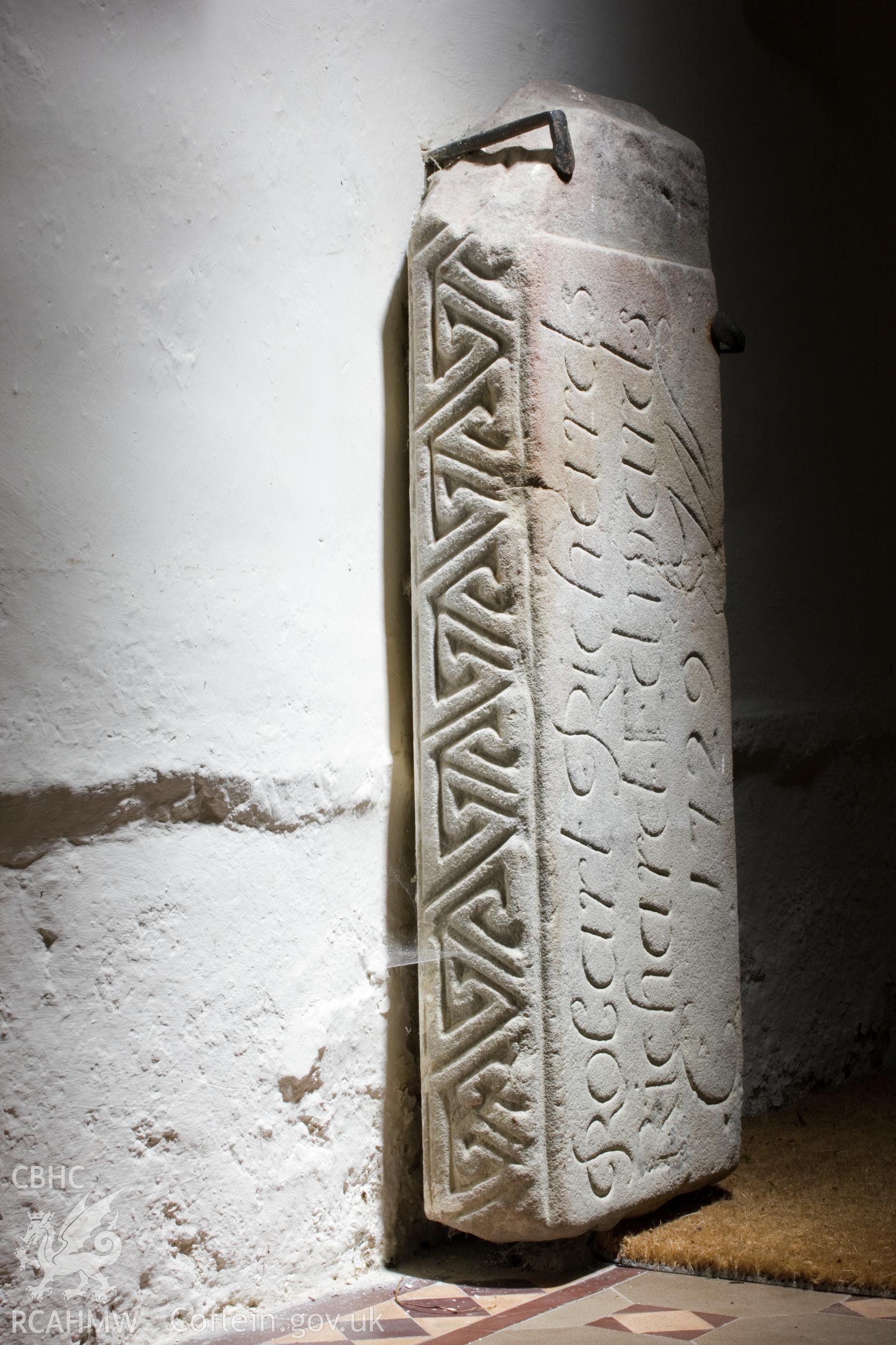 Early carved stone in porch, reused as gravestone.