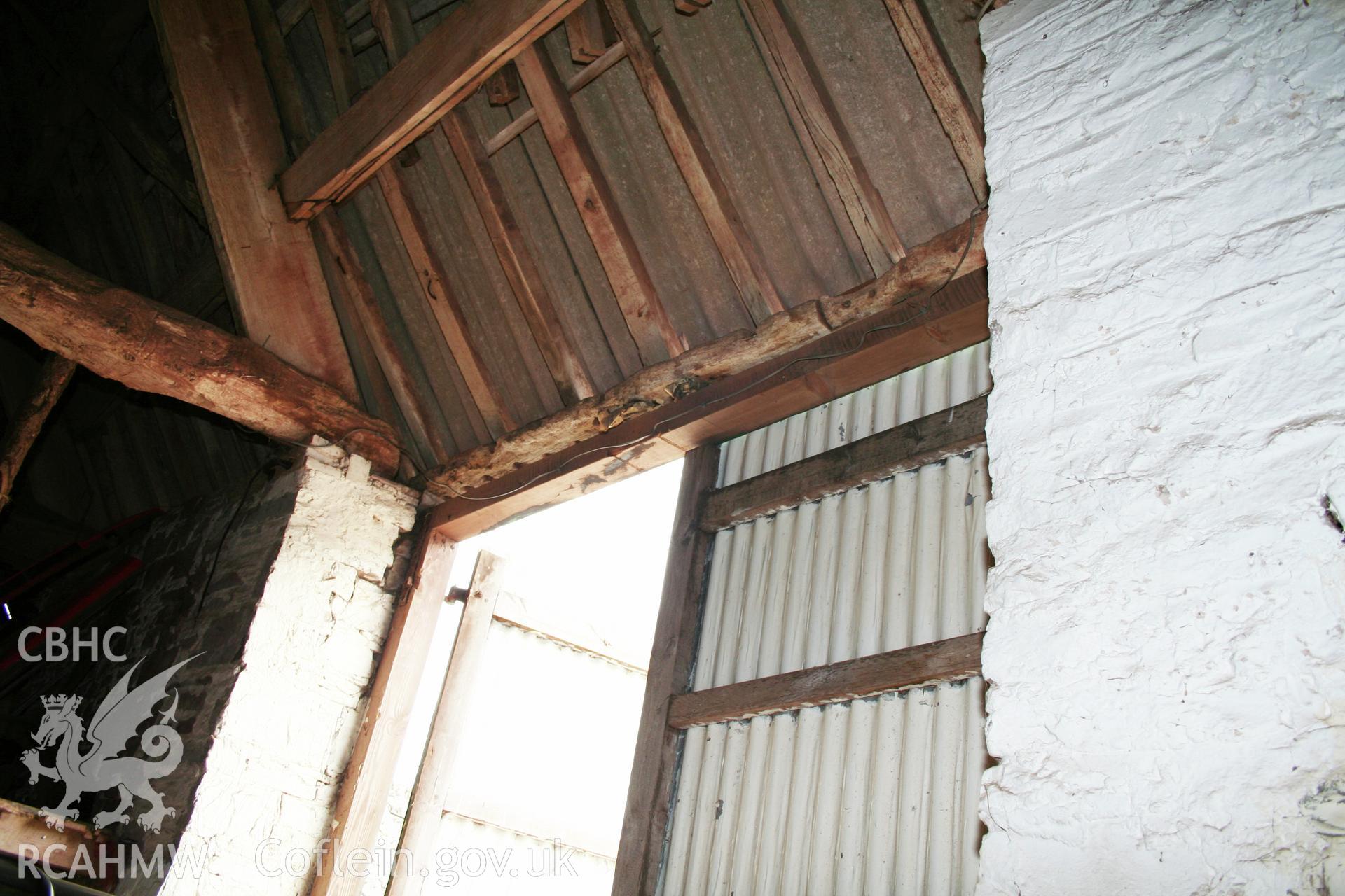 Interior of barn, threshing-bay doorway lintel.