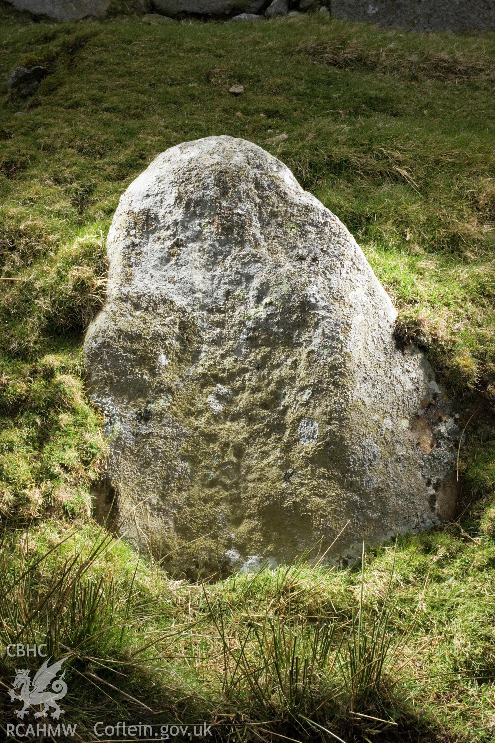 Cross carved stone (visible in middle of face, just below centre; taking up a third of the face).