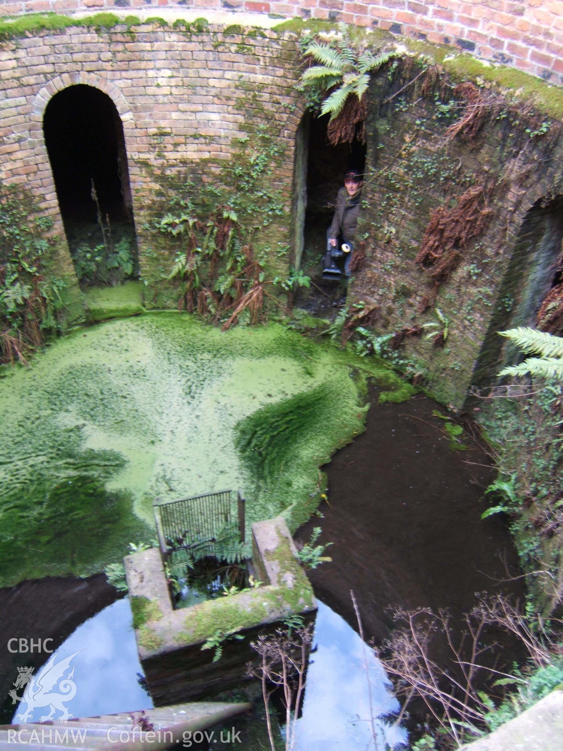 Iron access ladder down into slurry well with central drain & TV cameraman in support vaults.