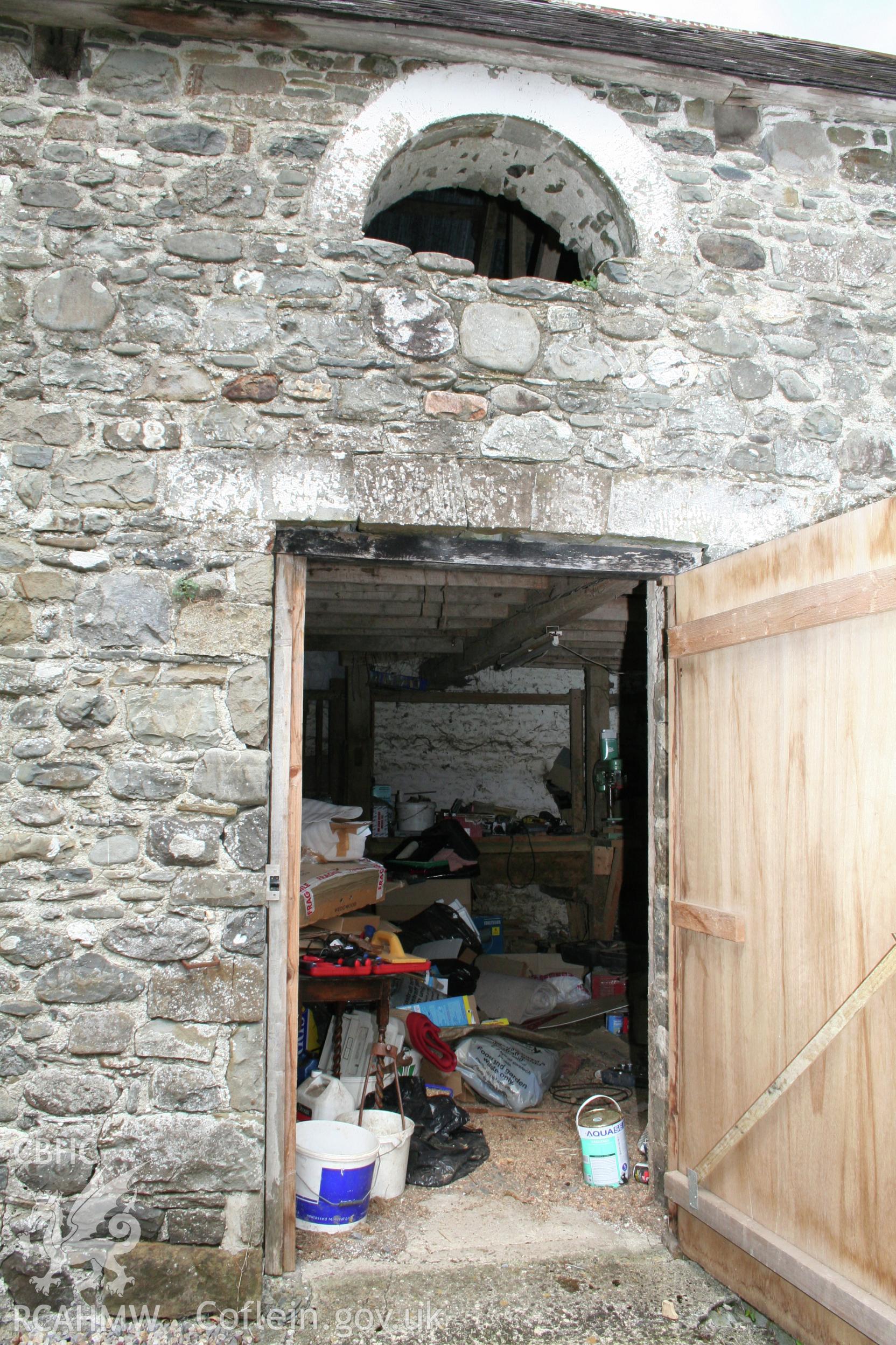 Stable south elevation doorway and arched loft opening.