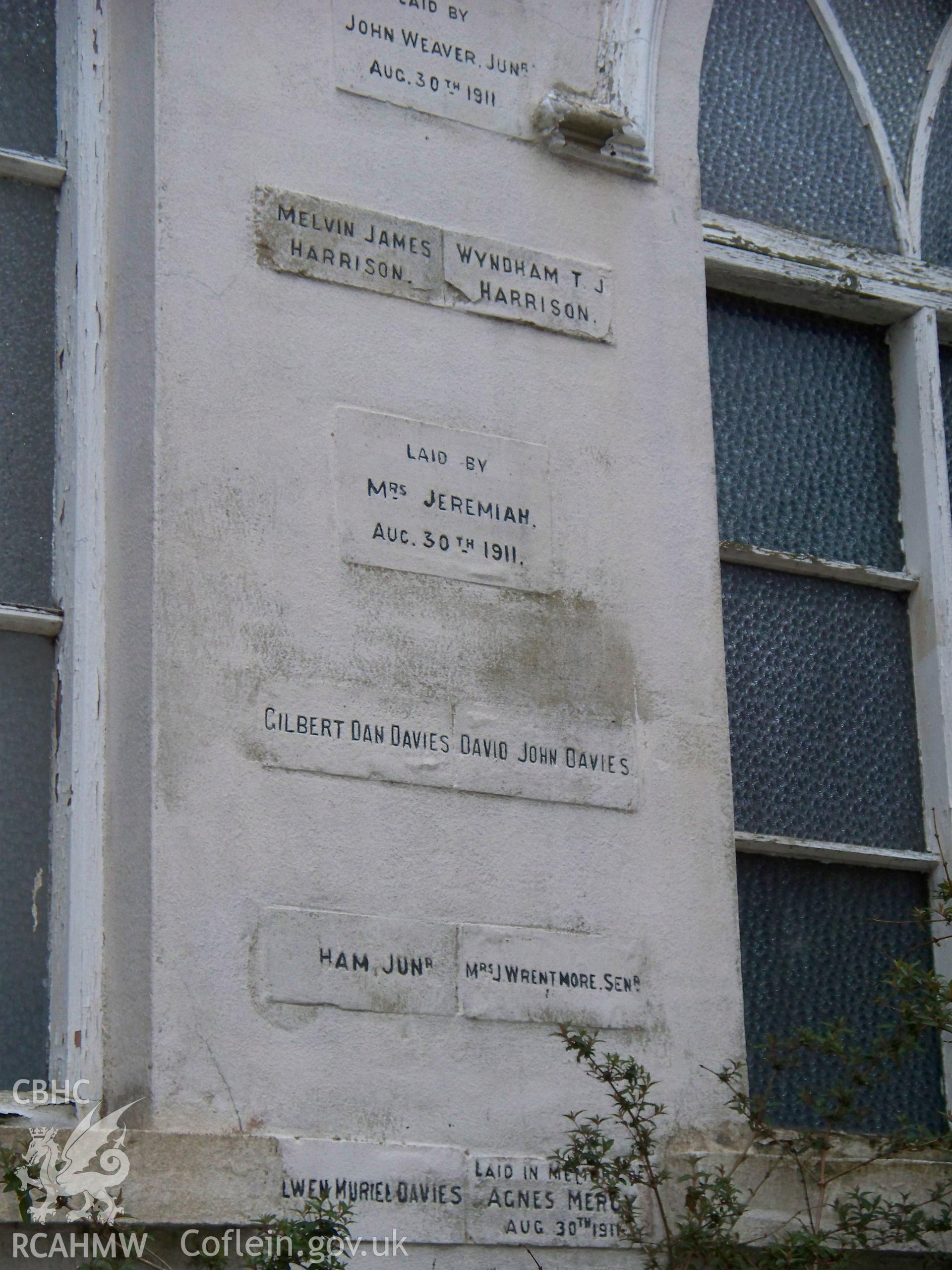 Multiple foundation stones and bricks on N gable, W side.