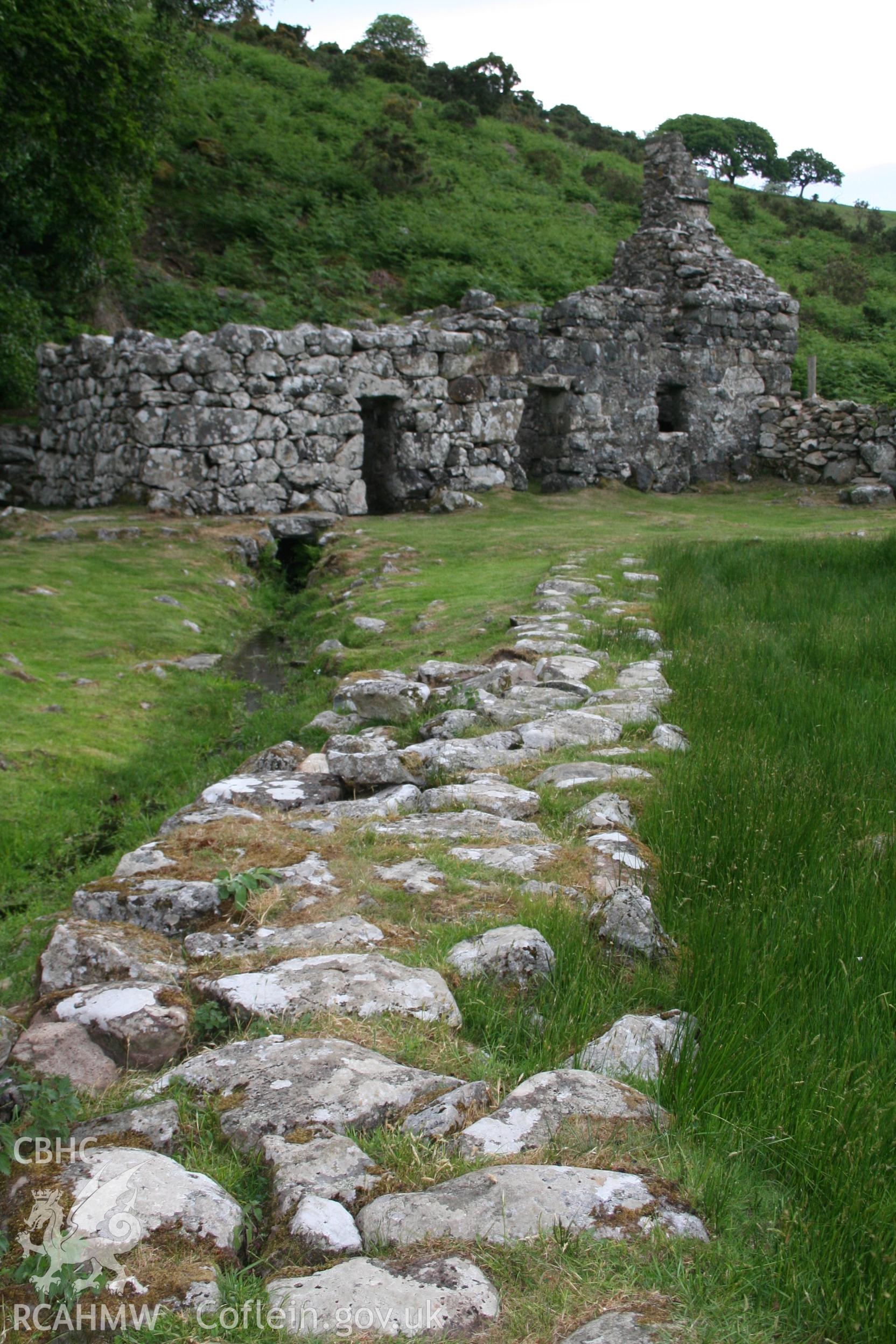 View towards well house and cottage along raised pathway that leads to latrine building.