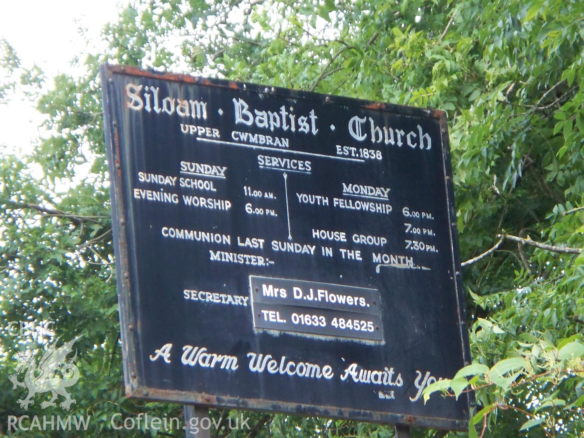 Order of services board in burial ground facing SE.