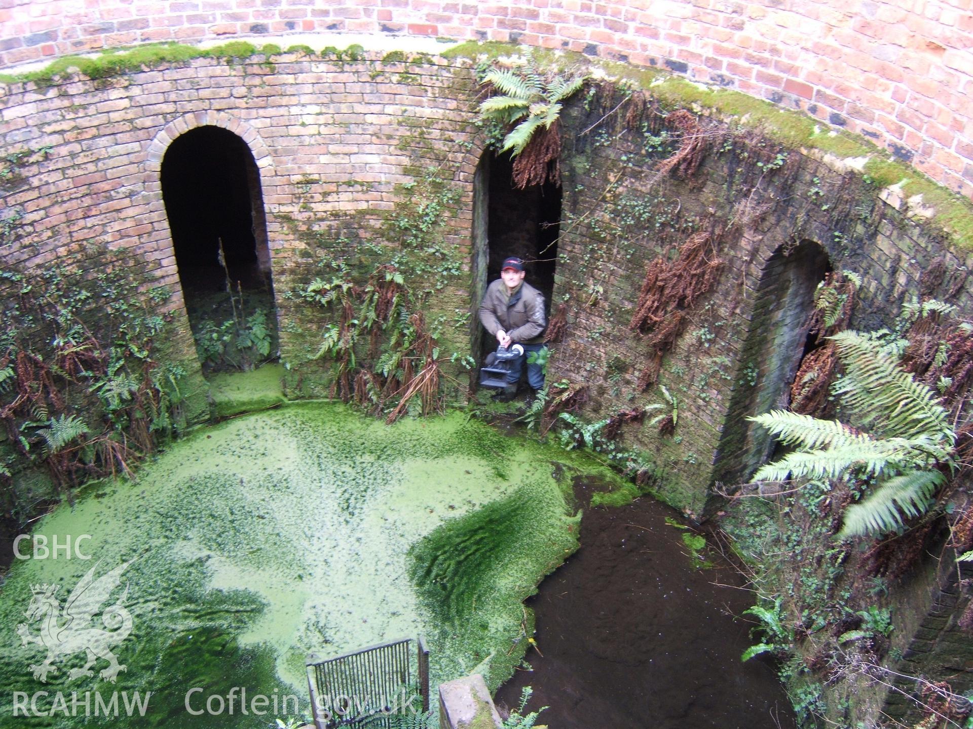 Looking from access door into slurry well with TV cameraman in arch of vaults under former sheep-house.