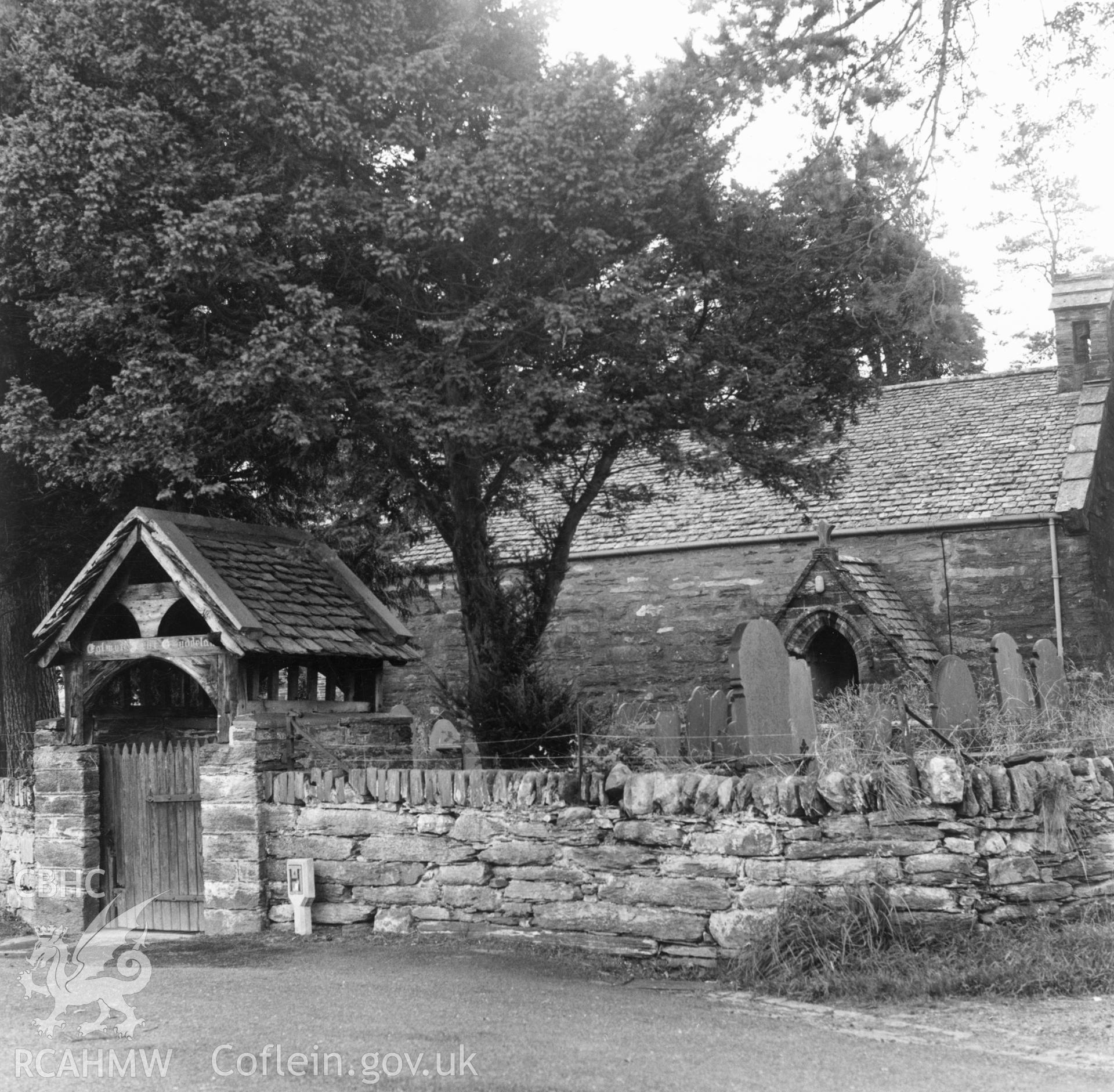 1 b/w print showing view of St Gwyddelan church, Dolwyddelan, showing lych-gate intact; collated by the former Central Office of Information.