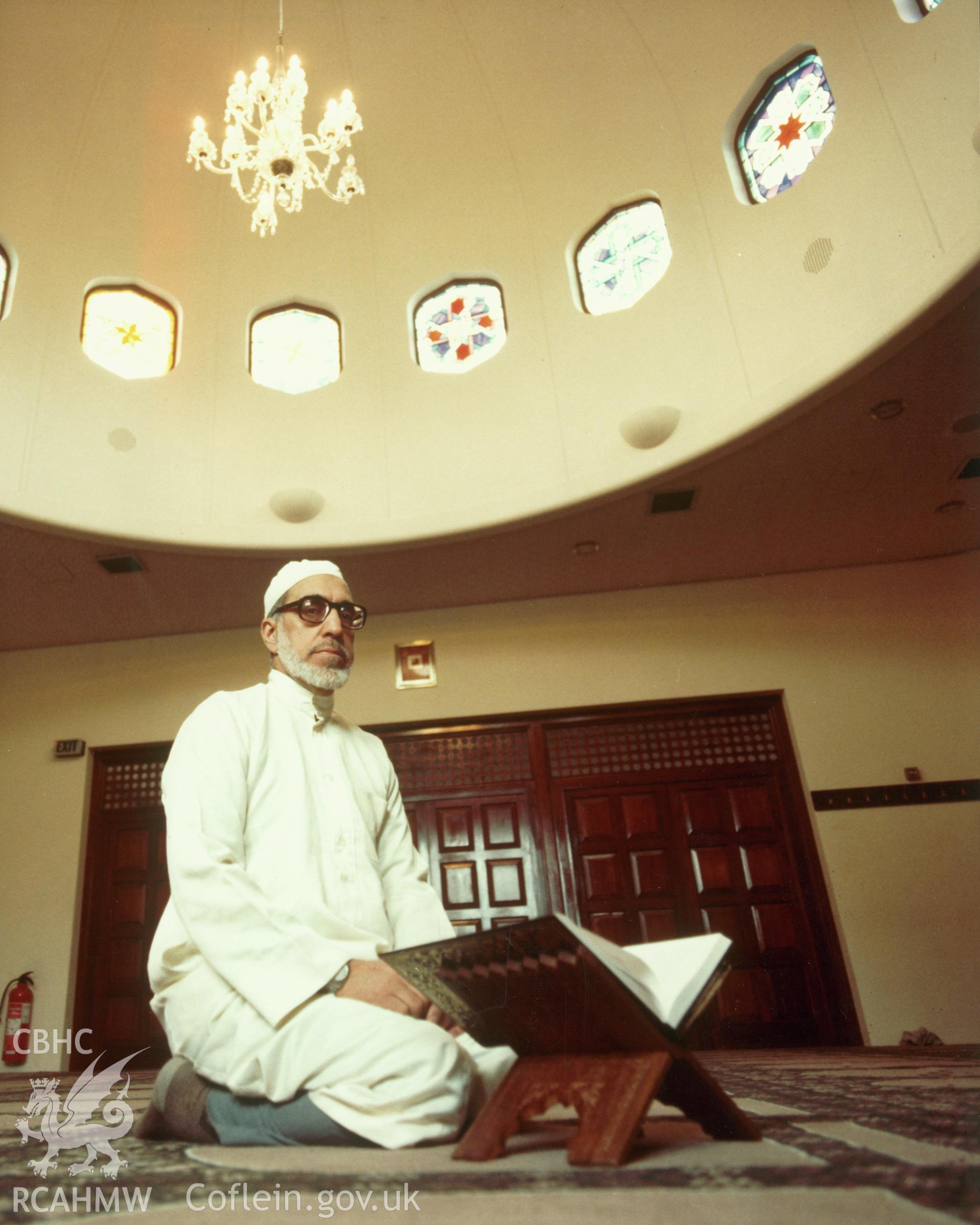 1 colour print showing interior of the South Wales Islamic Centre, Alice Street, Cardiff, with the Imam, Sheik Said at prayer; collated by the former Central Office of Information.