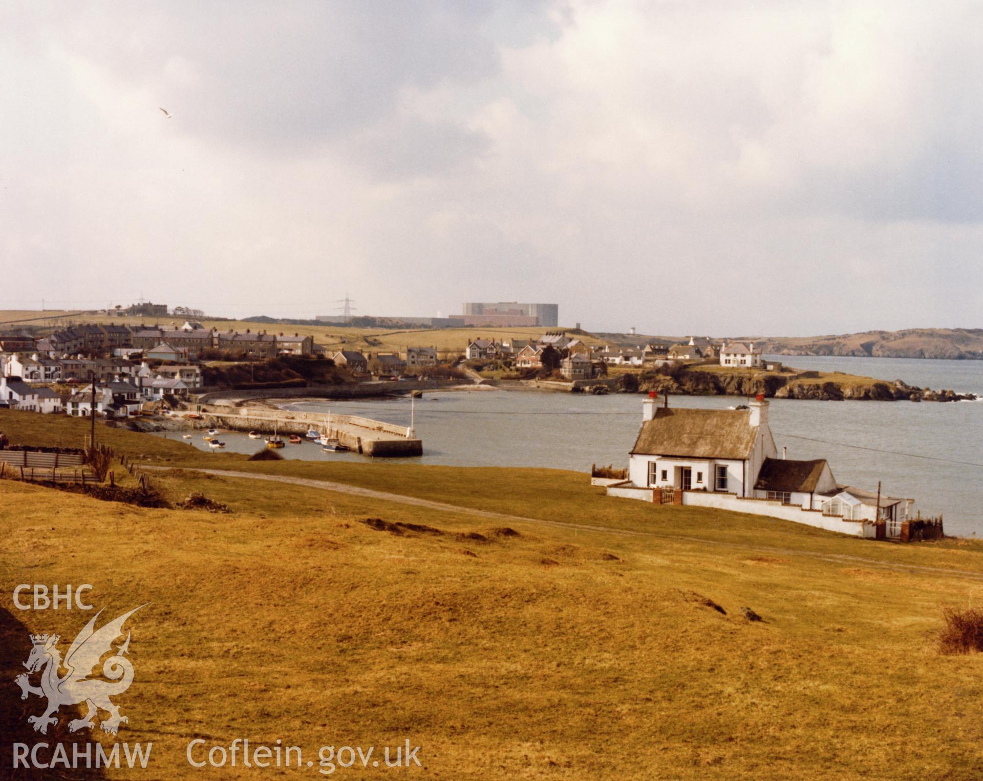 1 b/w print showing distant view of Wylfa Power Station with the village of Cemaes in the foreground; collated by the former Central Office of Information.