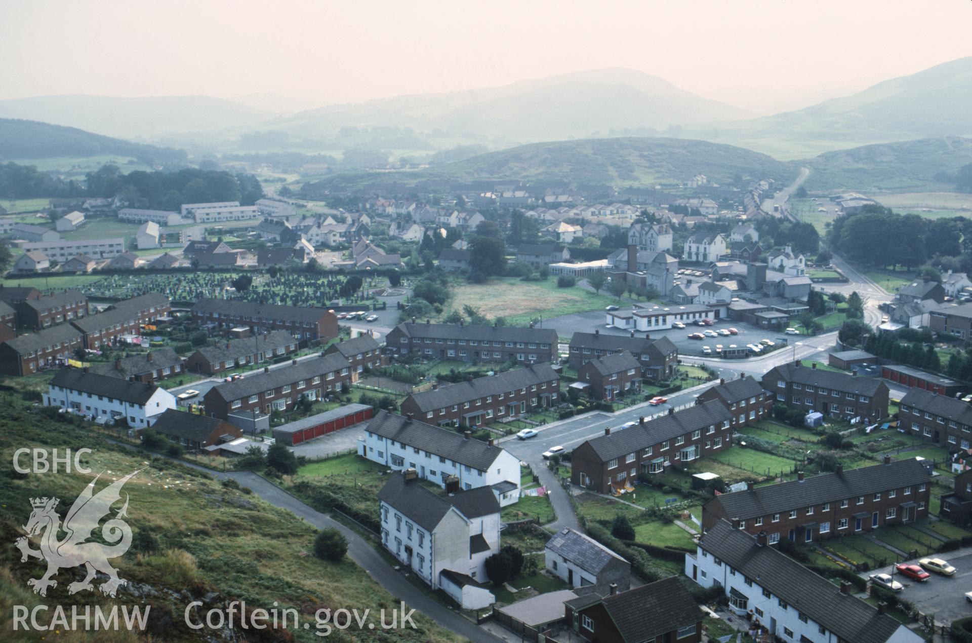 Colour photographic transparency showing aerial oblique view over Machynlleth town and council housing; collated by the former Central Office of Information.