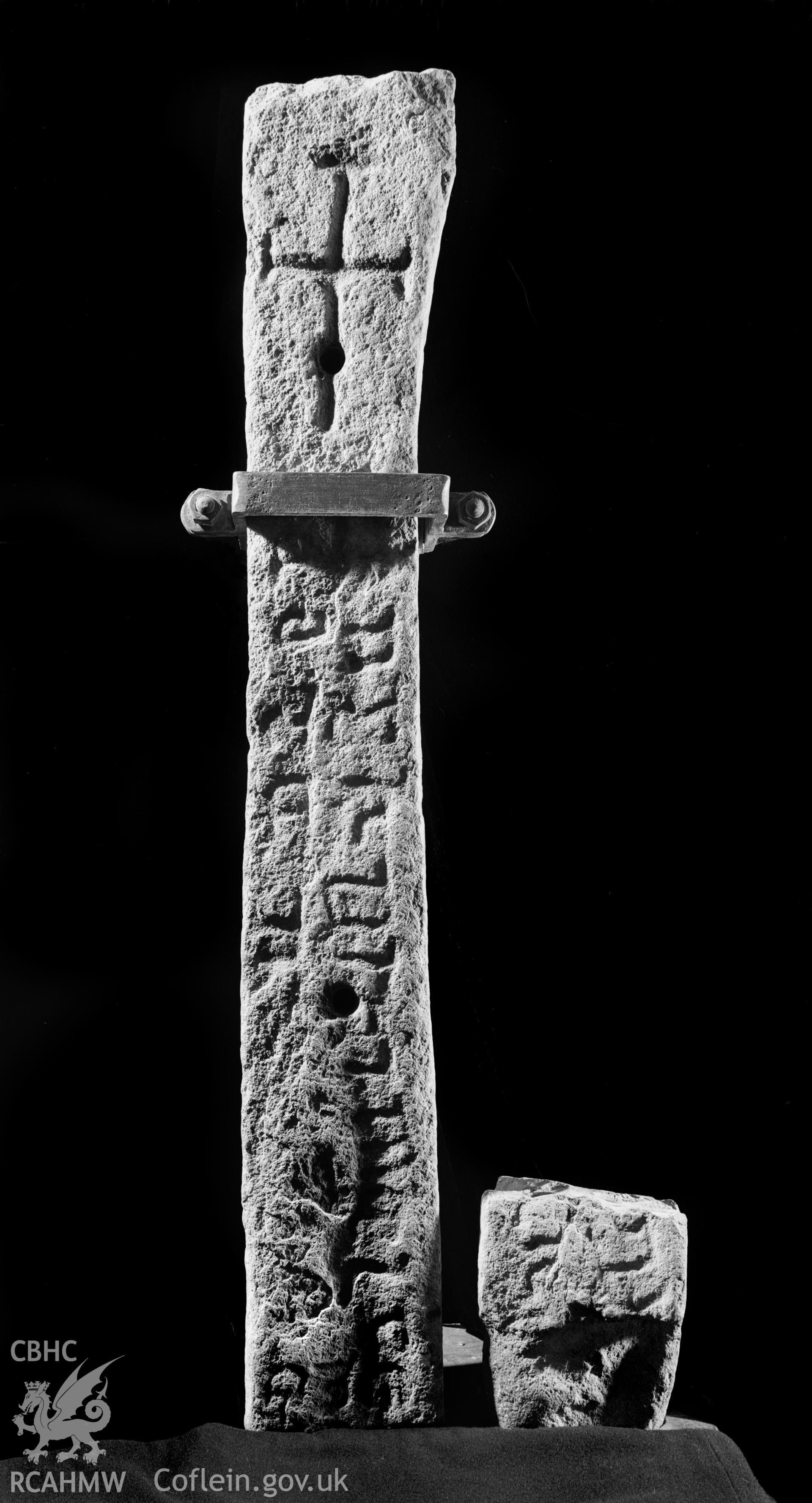 Black and white photograph of cross-carved stone with roman-letter inscription, St. Cadfan's Church, Tywyn: Corpus of Early Medieval Inscribed Stones and Stone Sculpture in Wales, Volume III, North Wales, Figure MR25.1, p.424.