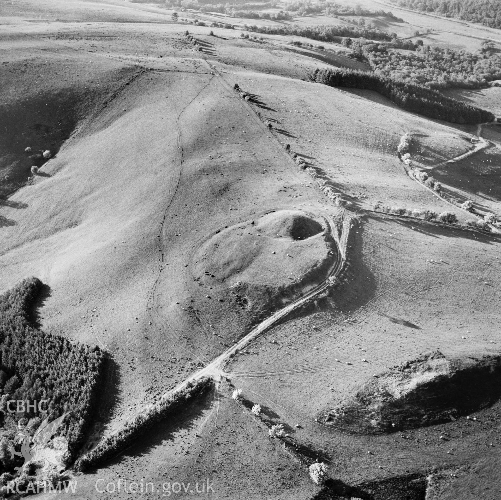 RCAHMW Black and white oblique aerial photograph of Tomen Bedd-ugre, Llanddewi Ystradenny, taken by CR Musson on 13/06/88