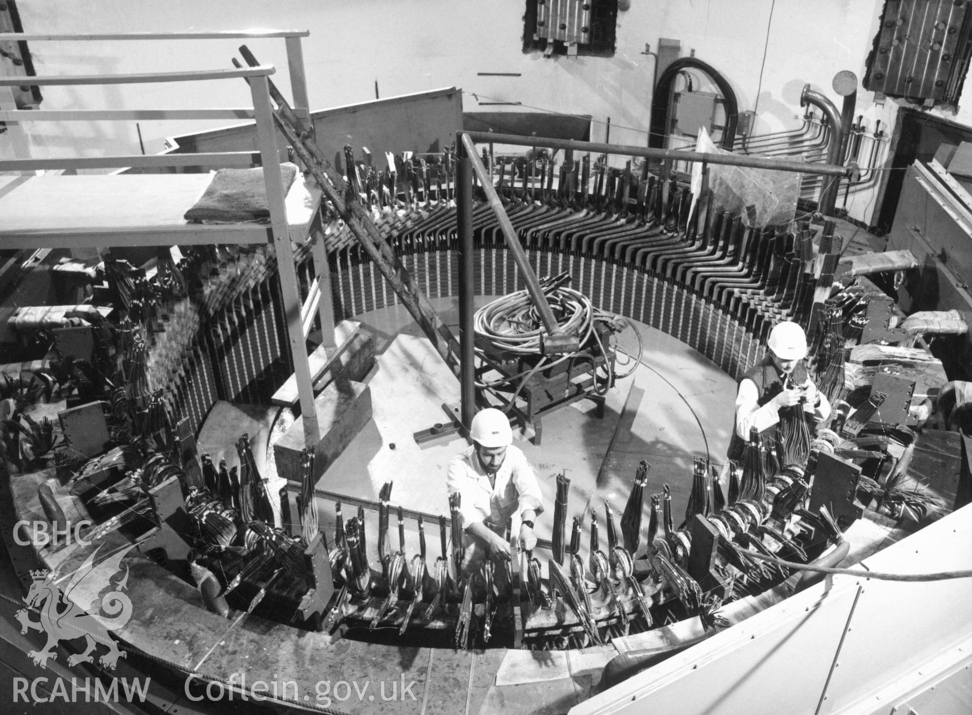 1 b/w print showing engineers assembling the stator on one of the pump-turbines in the main machine hall of Dinorwig Power Station; collated by the former Central Office of Information.