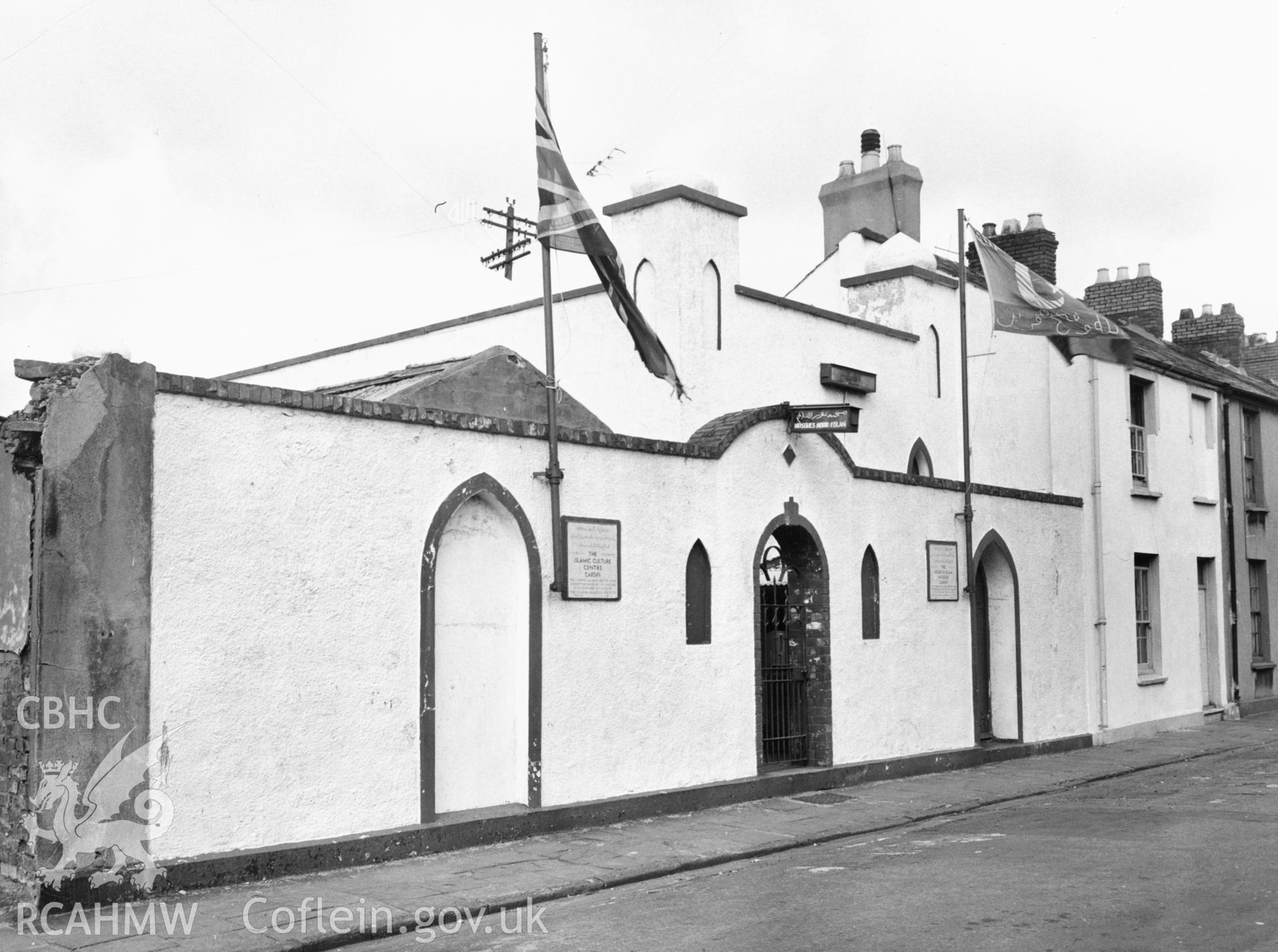 View of Peel Street Mosque, Cardiff, taken in 1964. Built in 1947, this was the first purpose-built mosque in Wales established by the sea-faring Yemeni community which settled around Cardiff docks.  It was a white painted rendered building with a small dome and minarets, looked charming and traditional.