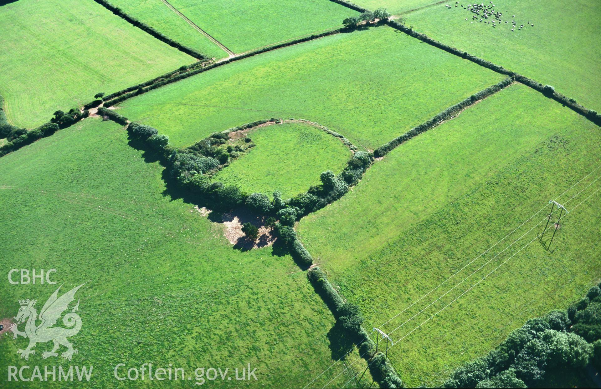 RCAHMW colour oblique aerial photograph of Woodbarn Rath, Wiston, earthwork enclosure; view from north-east. Taken by C R Musson on 24/07/1995