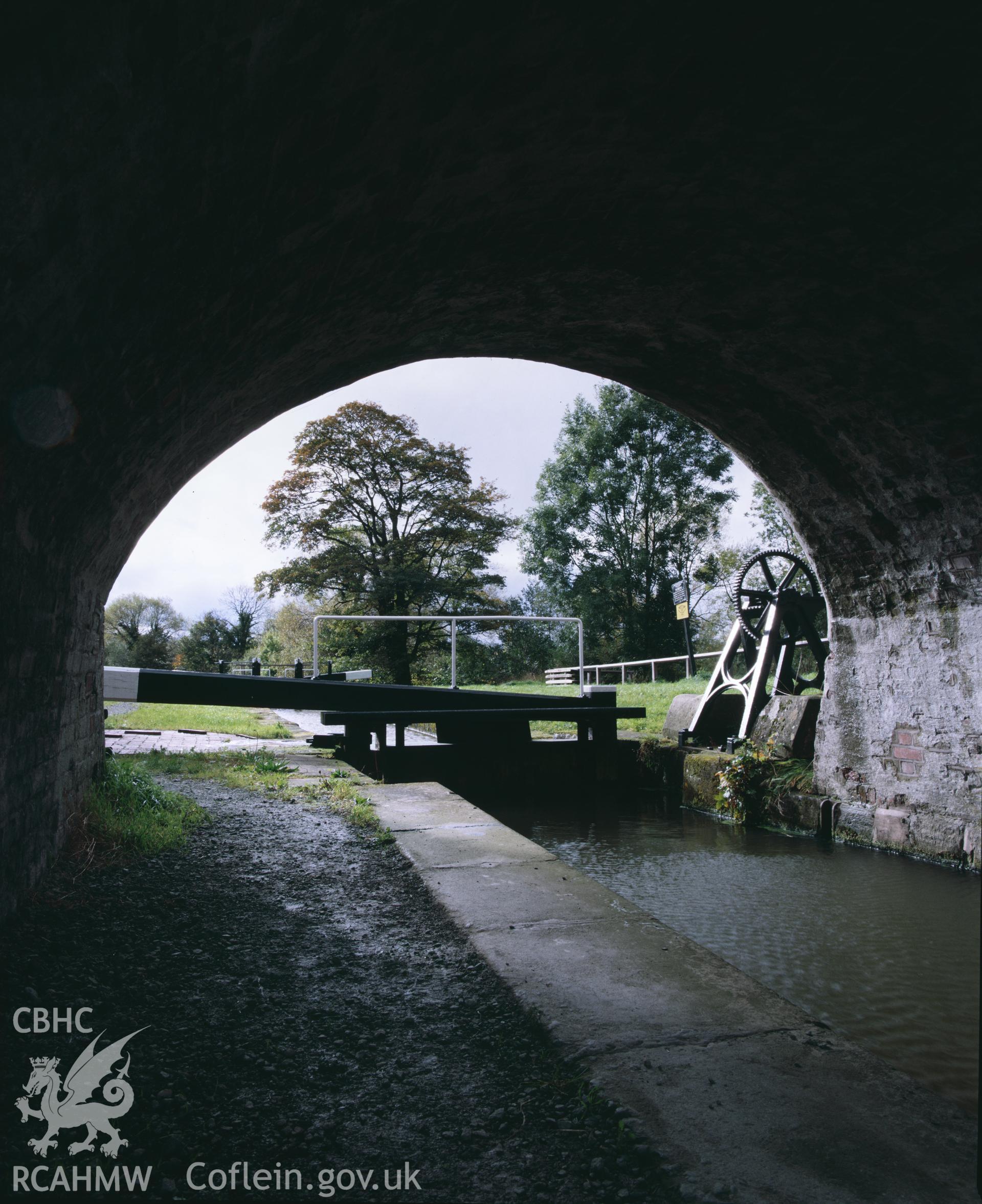 Colour transparency showing a view from under the bridge at Burgedin Lock on the Montgomeryshire Canal, produced by Iain Wright 1980