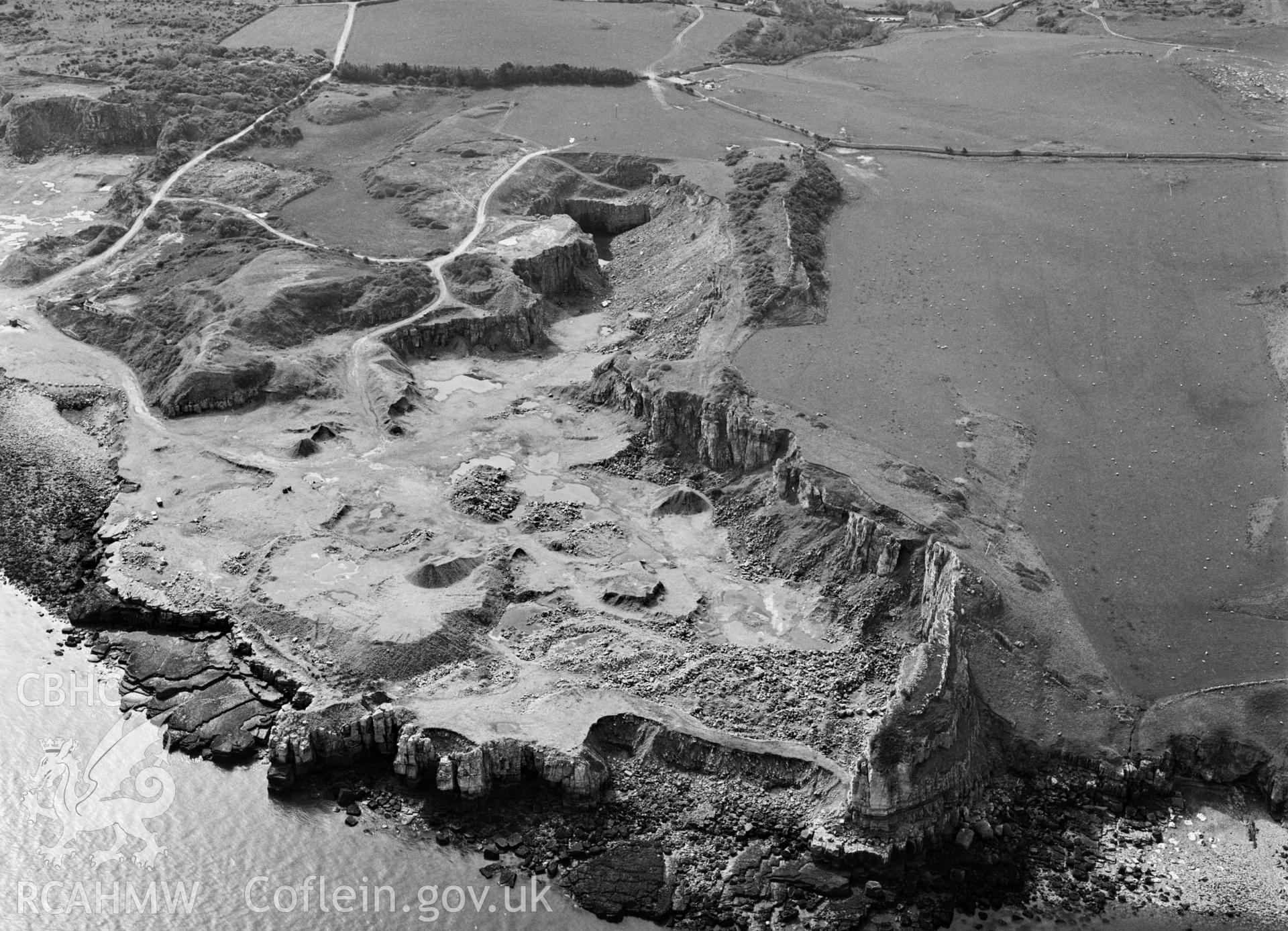 RCAHMW Black and white oblique aerial photograph of Dinmor Park Limestone Quarries (disused), Llangoed, taken by C.R. Musson, 01/05/94