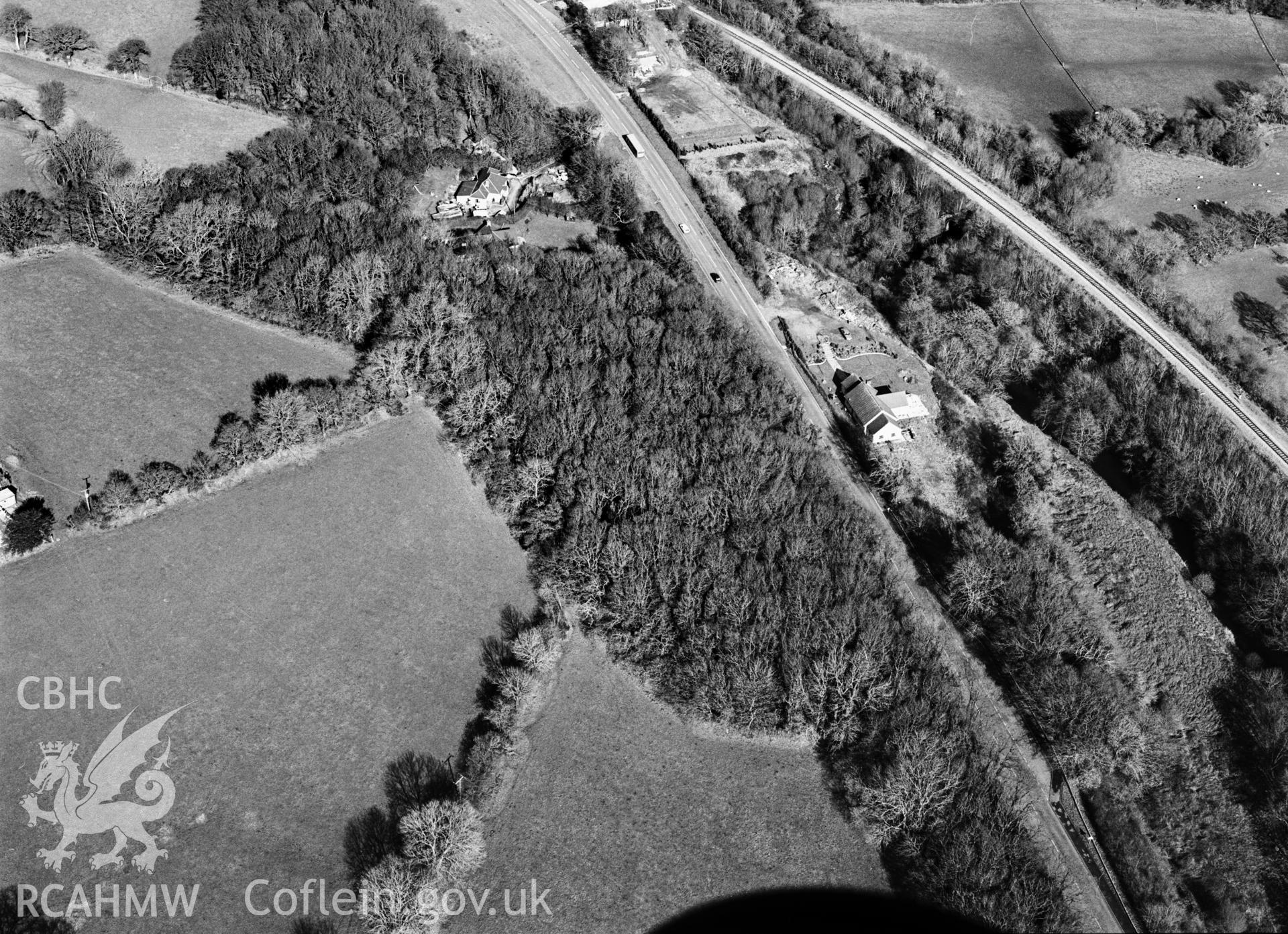 RCAHMW black and white oblique aerial photograph of Pant Lladron Enclosure (Great Treffgarne Wood Camp), taken by C R Musson, 27/02/1996.