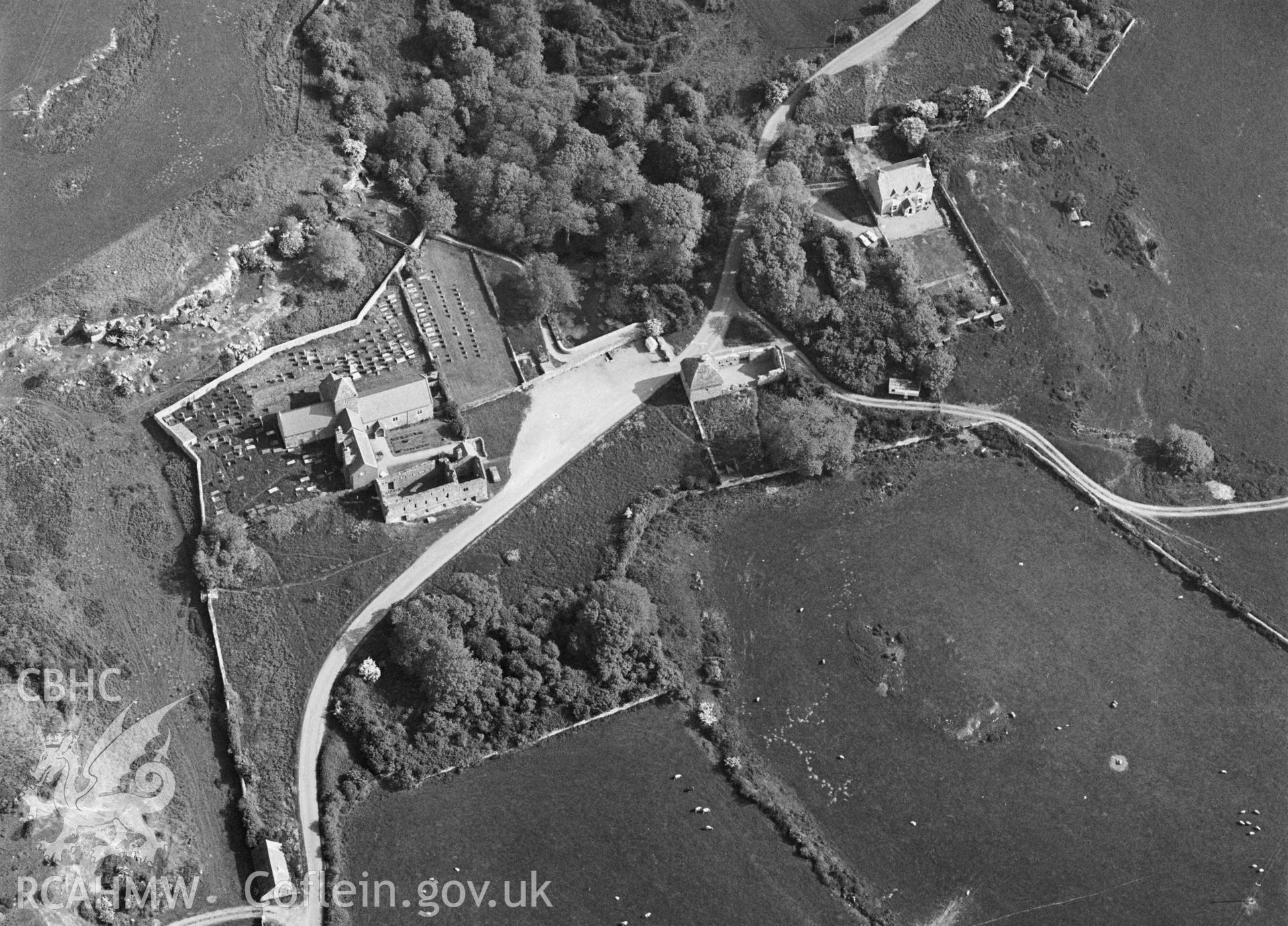 RCAHMW Black and white oblique aerial photograph of Penmon Priory, Penmon, taken by C.R. Musson, 30/05/94