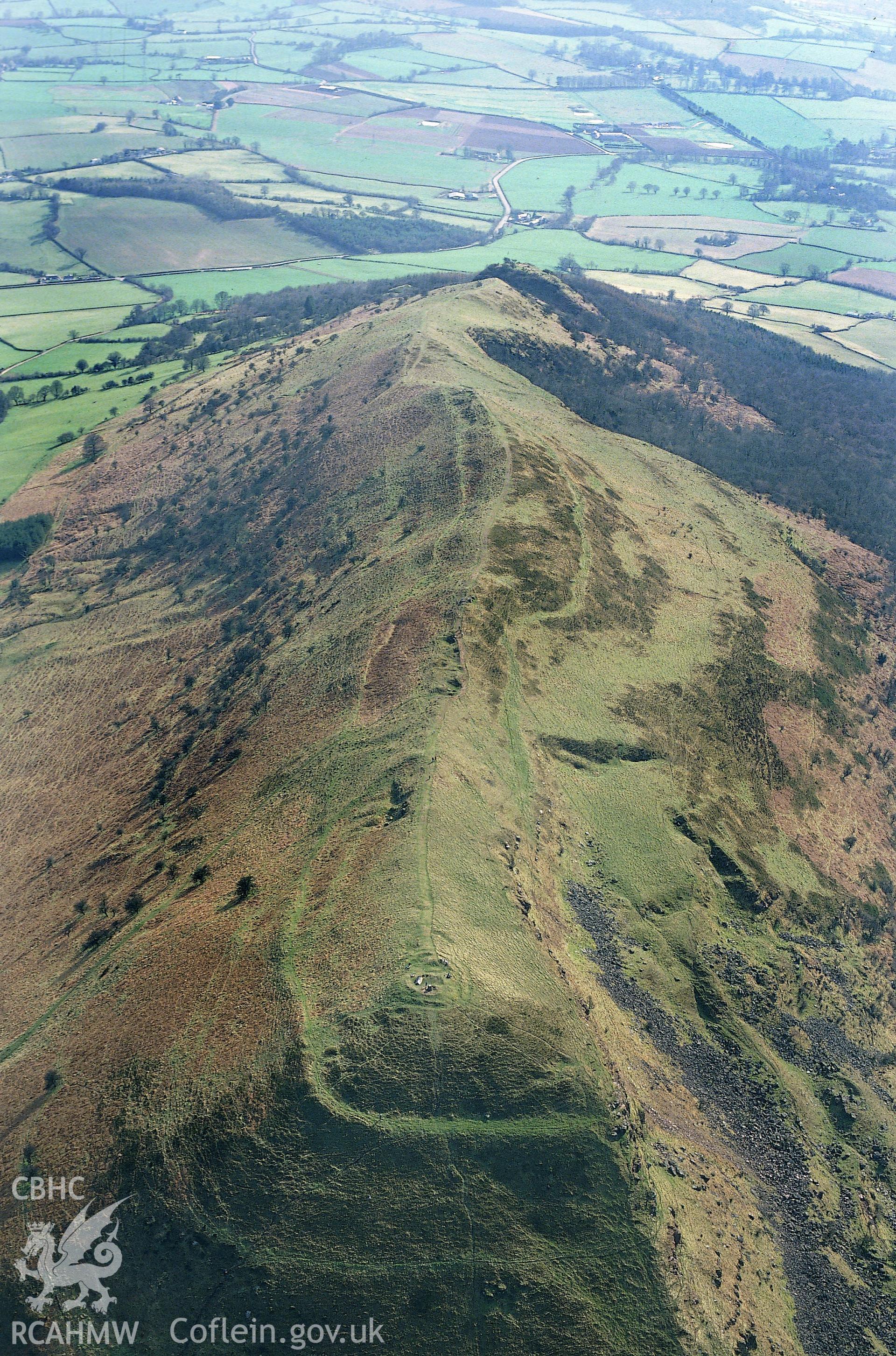 RCAHMW colour slide oblique aerial photograph of Skirrid Fawr Summit Enclosure, Llantilio Pertholey, taken by C.R. Musson, 26/03/94