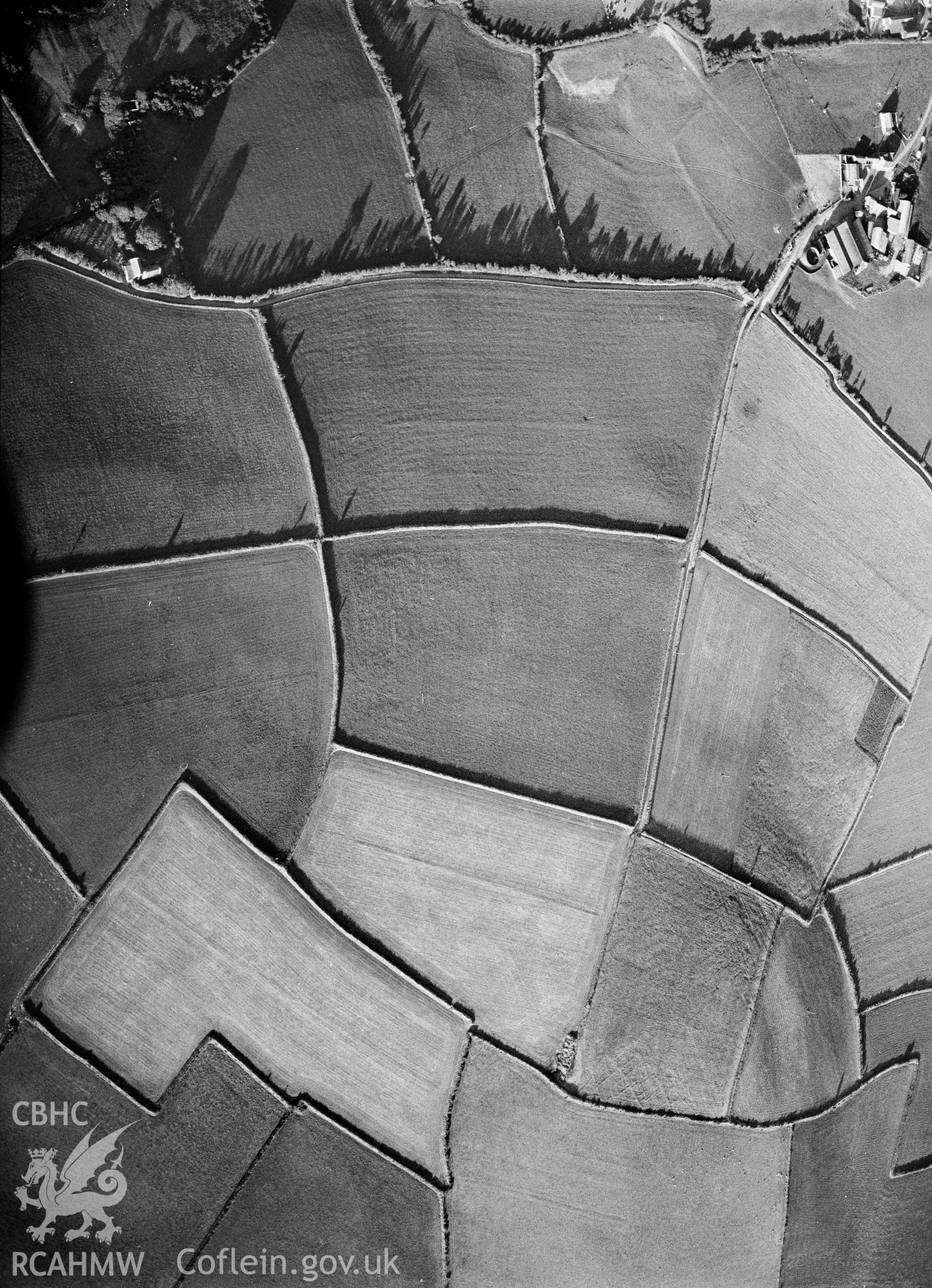 RCAHMW black and white oblique aerial photograph of cropmark enclosures south-west of Nant Fflyman, Y Ferwig, taken 1990.