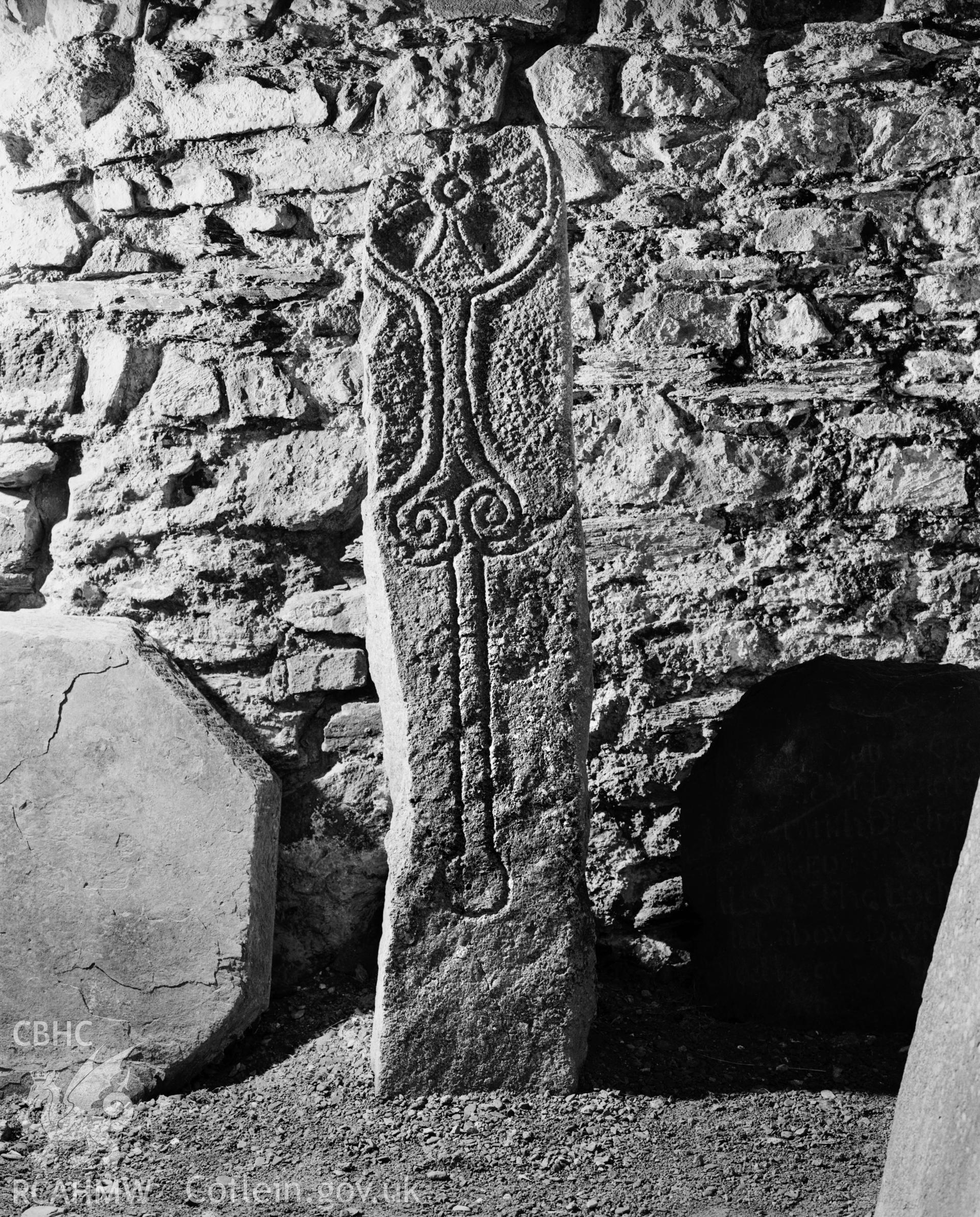 Digitised copy of an RCAHMW black and white photograph showing the Sagranus Stone,  at St Thomas's Church, St Dogmaels.