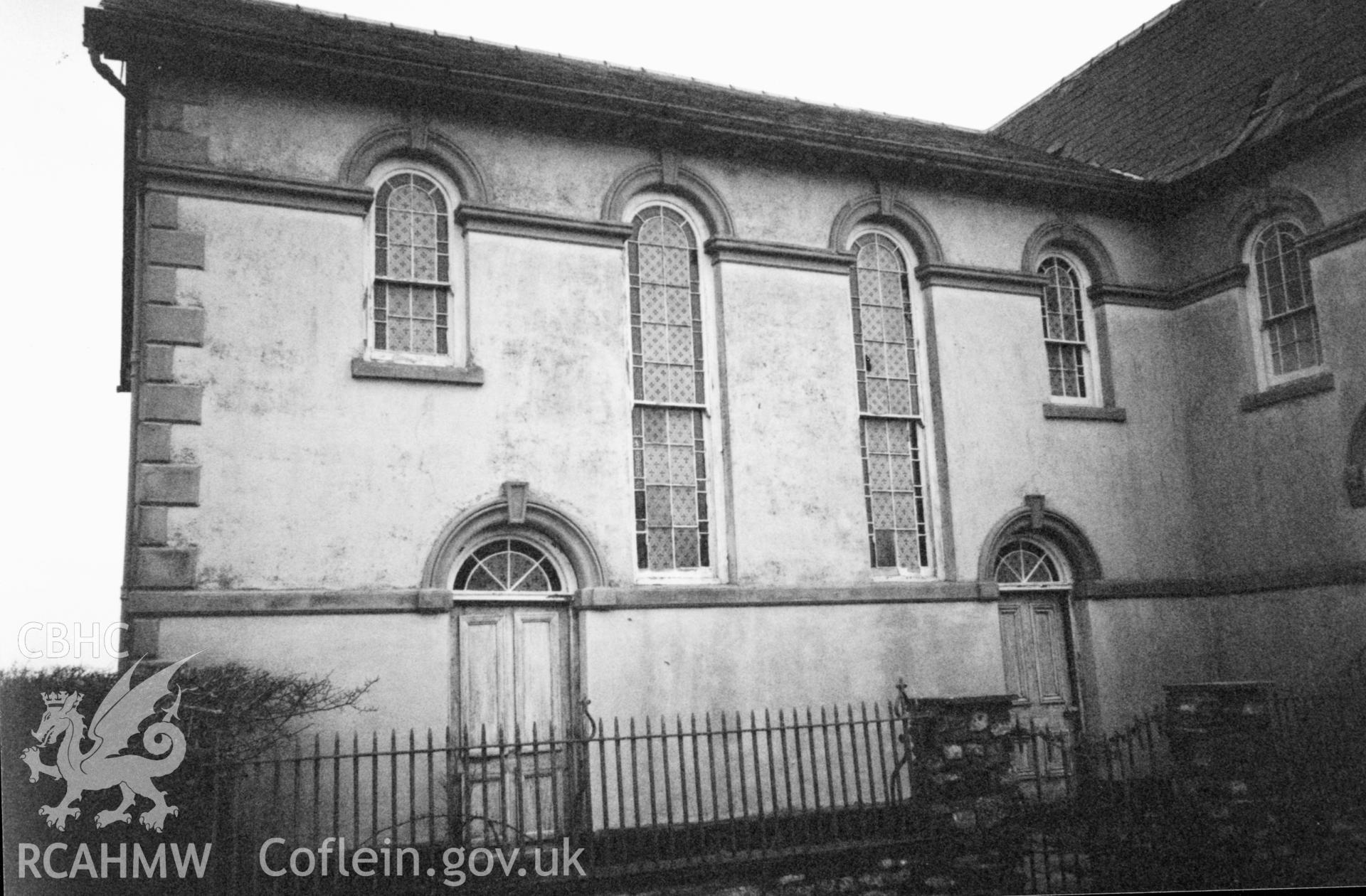 Digital copy of a black and white photograph showing an exterior view of Seion Calvinistic Methodist Chapel, Llansadwrn, taken by Robert Scourfield, 1996.