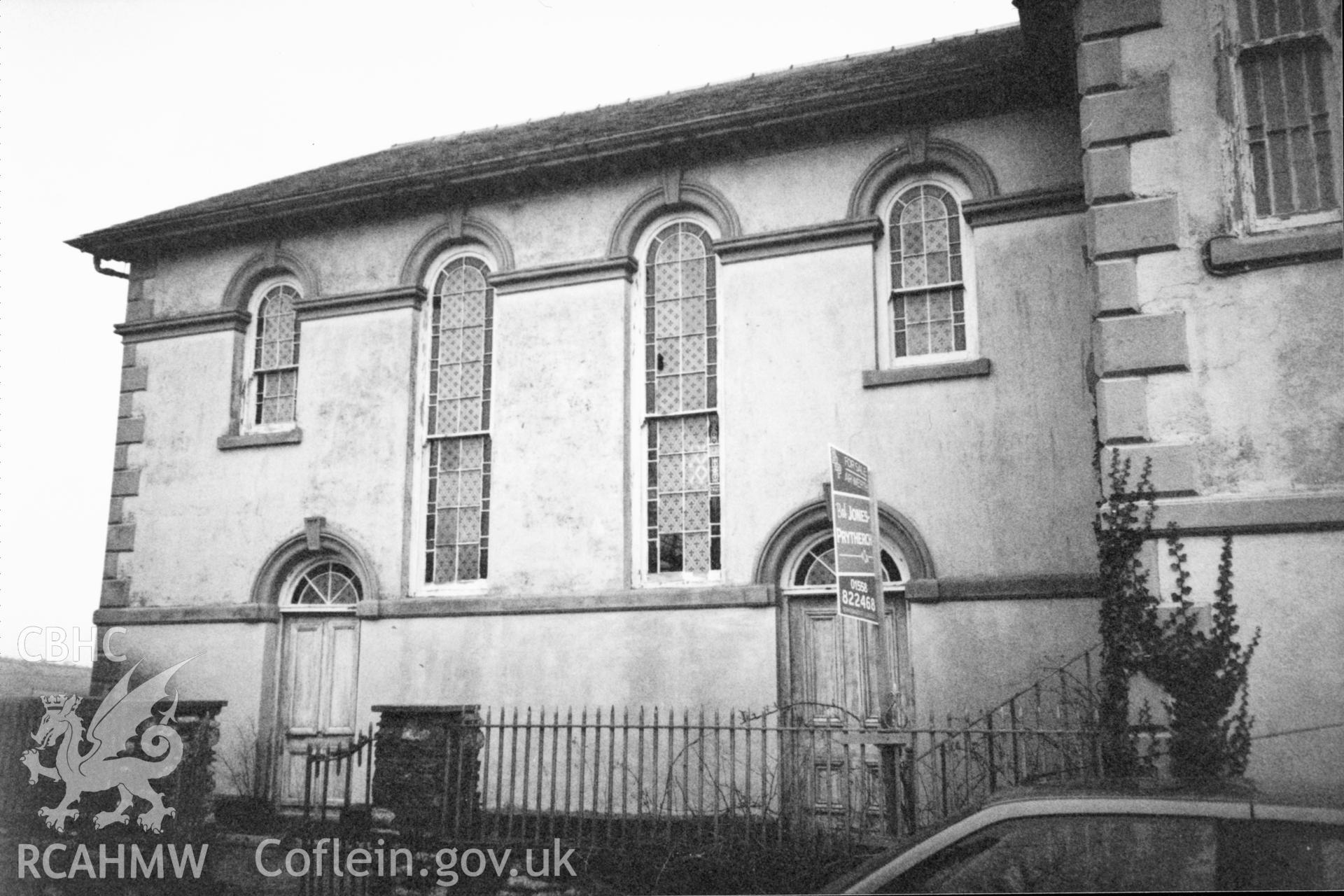 Digital copy of a black and white photograph showing an exterior view of Seion Calvinistic Methodist Chapel, Llansadwrn, taken by Robert Scourfield, 1996.