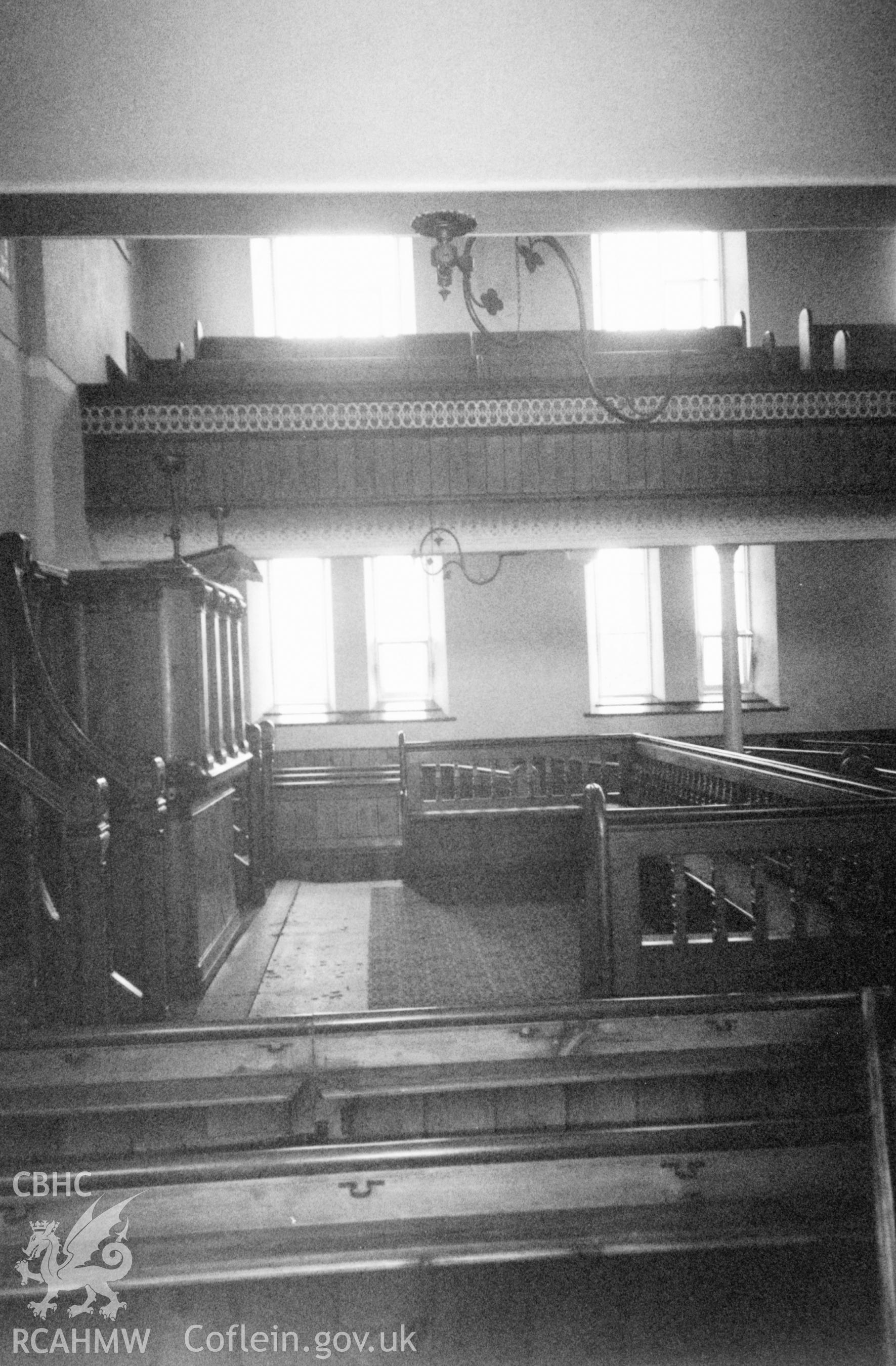 Digital copy of a black and white photograph showing an interior view of Ebeneser Welsh Independent Chapel, Llansadwrn, taken by Robert Scourfield, 1996.