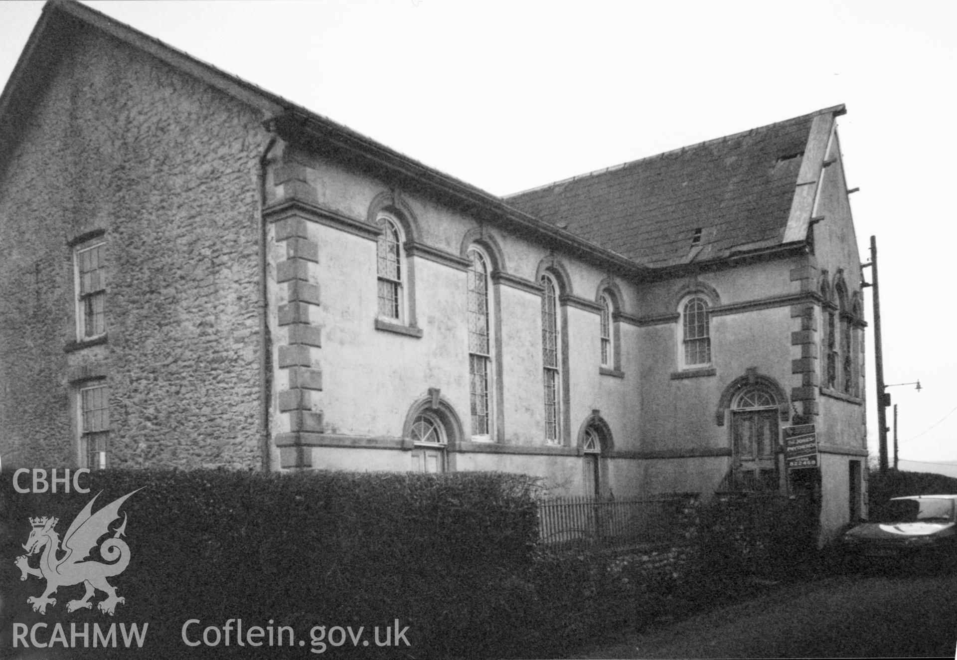 Digital copy of a black and white photograph showing an exterior view of Seion Calvinistic Methodist Chapel, Llansadwrn, taken by Robert Scourfield, 1996.