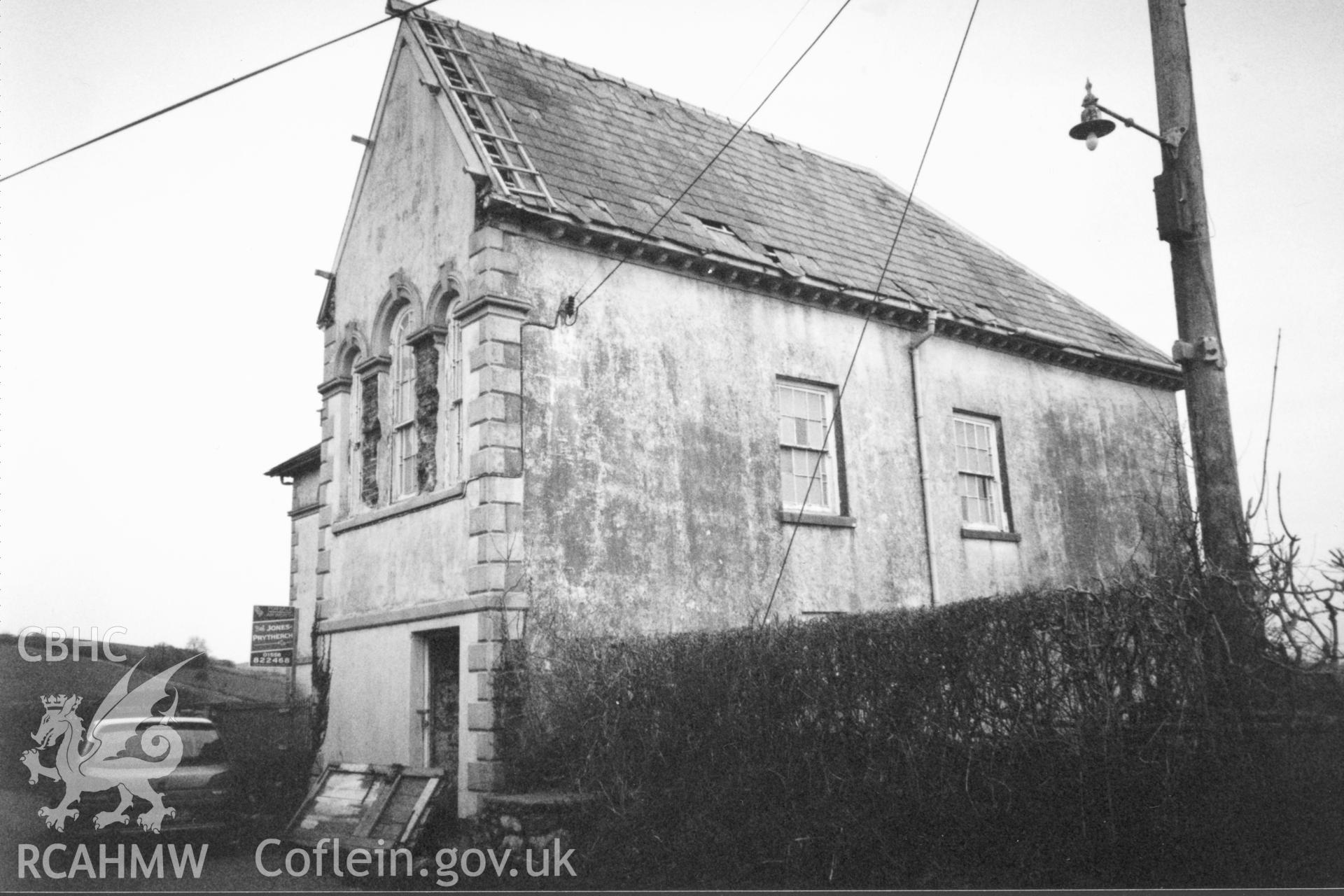 Digital copy of a black and white photograph showing an exterior view of Seion Calvinistic Methodist Chapel, Llansadwrn, taken by Robert Scourfield, 1996.