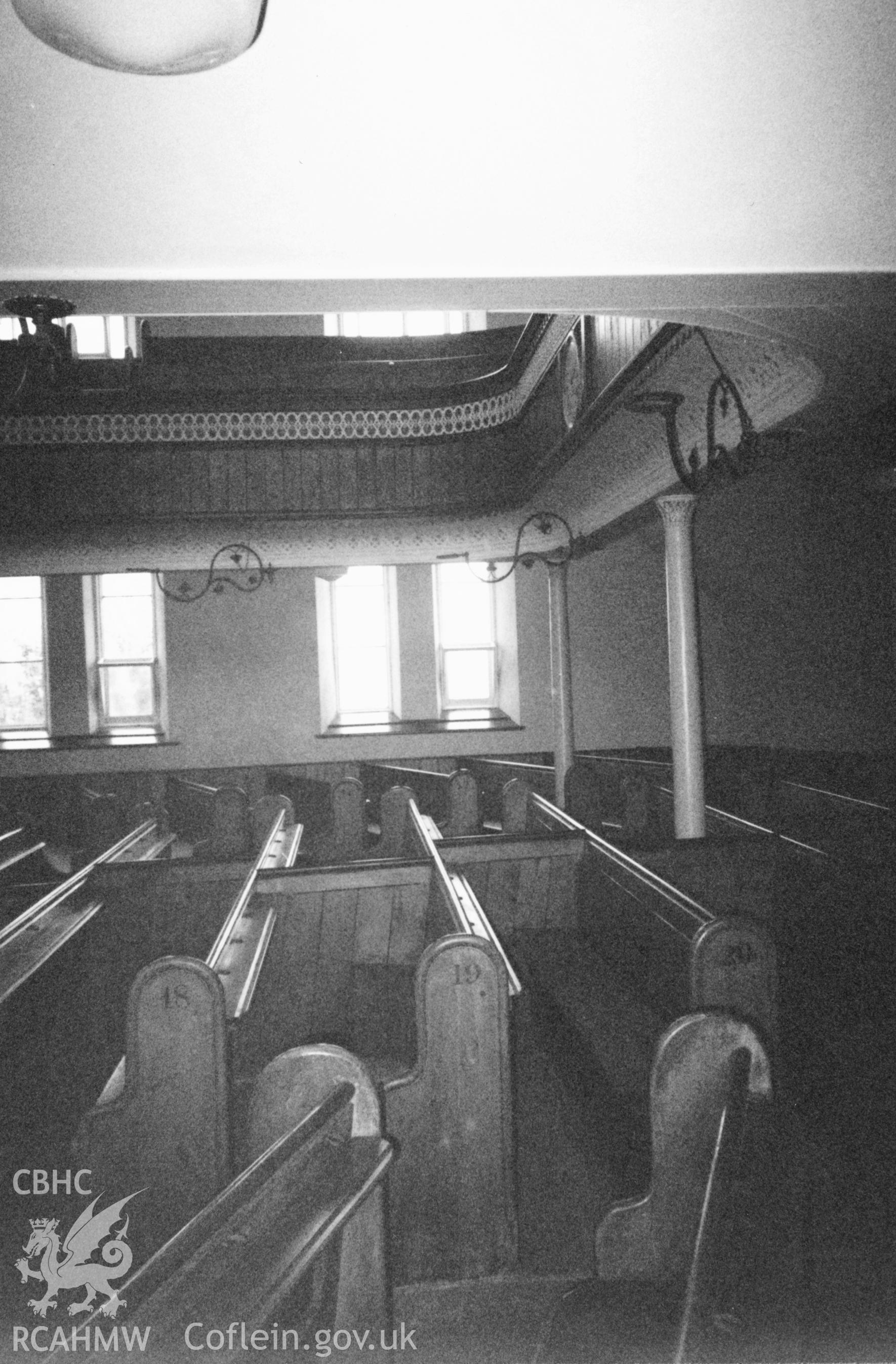 Digital copy of a black and white photograph showing an interior view of Ebeneser Welsh Independent Chapel, Llansadwrn, taken by Robert Scourfield, 1996.