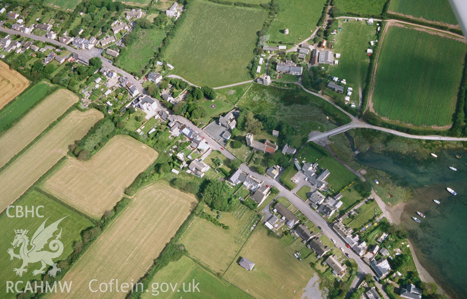 RCAHMW colour oblique aerial photograph of Angle, village-scape, with St. Mary's Church. Taken by Toby Driver on 28/06/2002