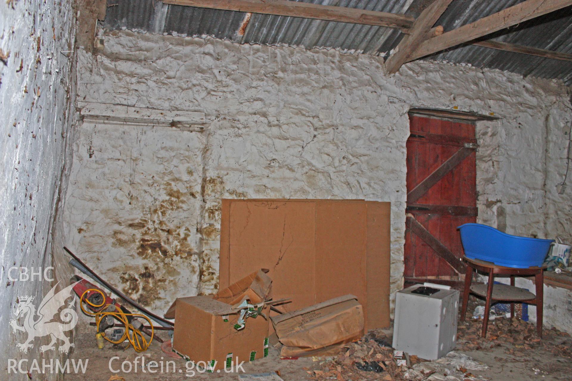 Interior, south-east wall of cow-house showing blocked doorway.