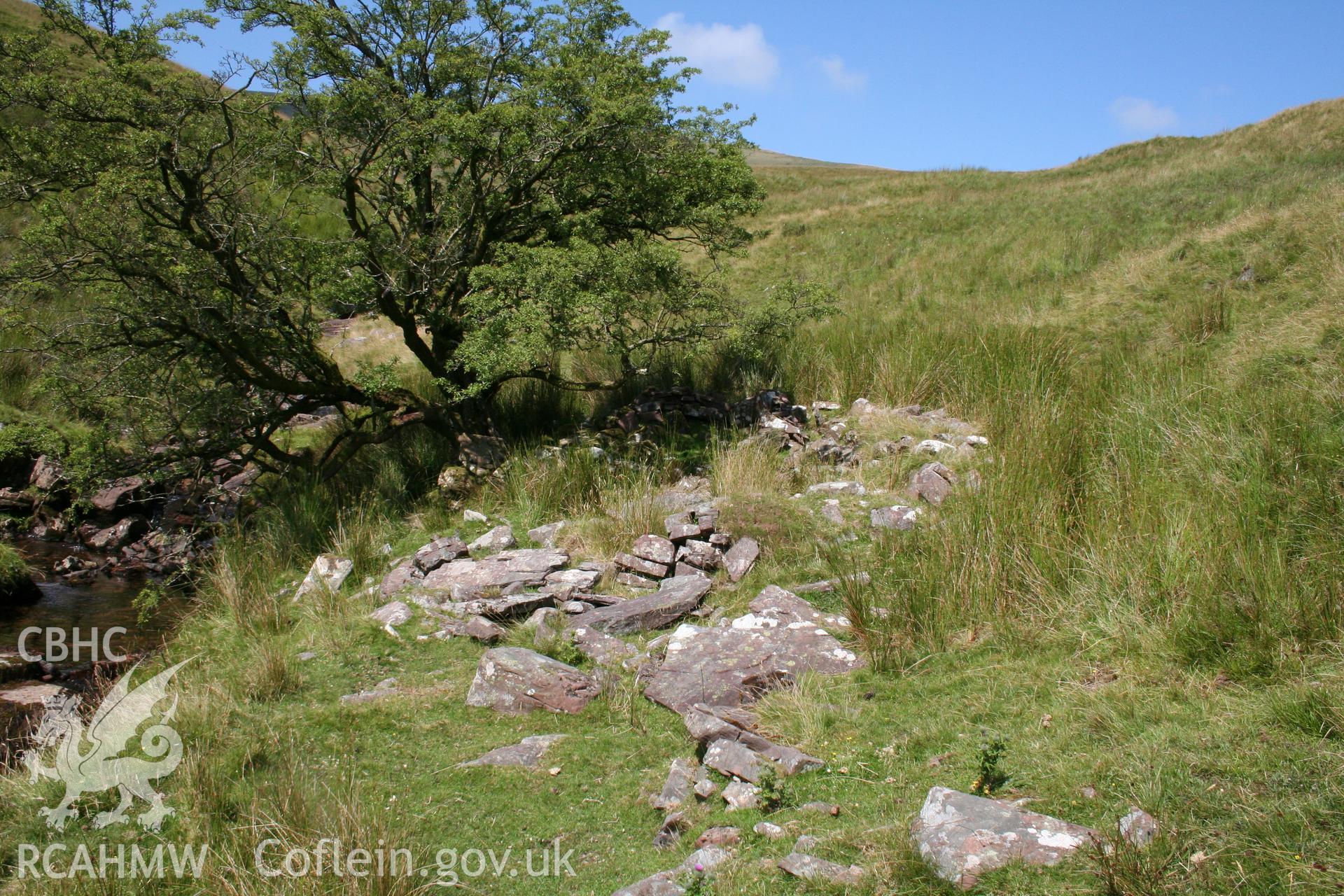Long hut seen from the east, 'revetment' wall in foreground.