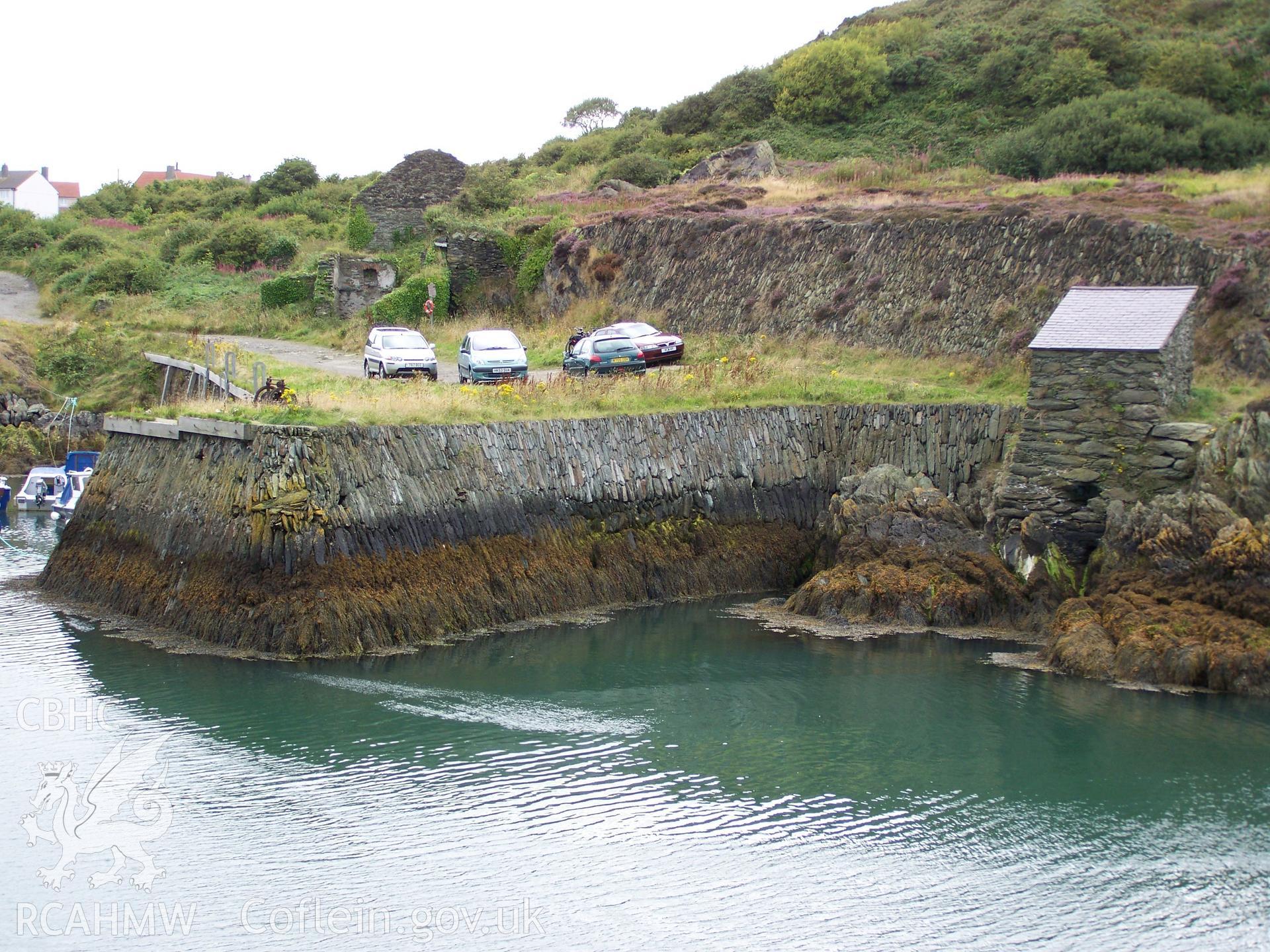 Viewed from eastern side of the harbour and showing the slate roof and the back wall opening to the sea at its base.