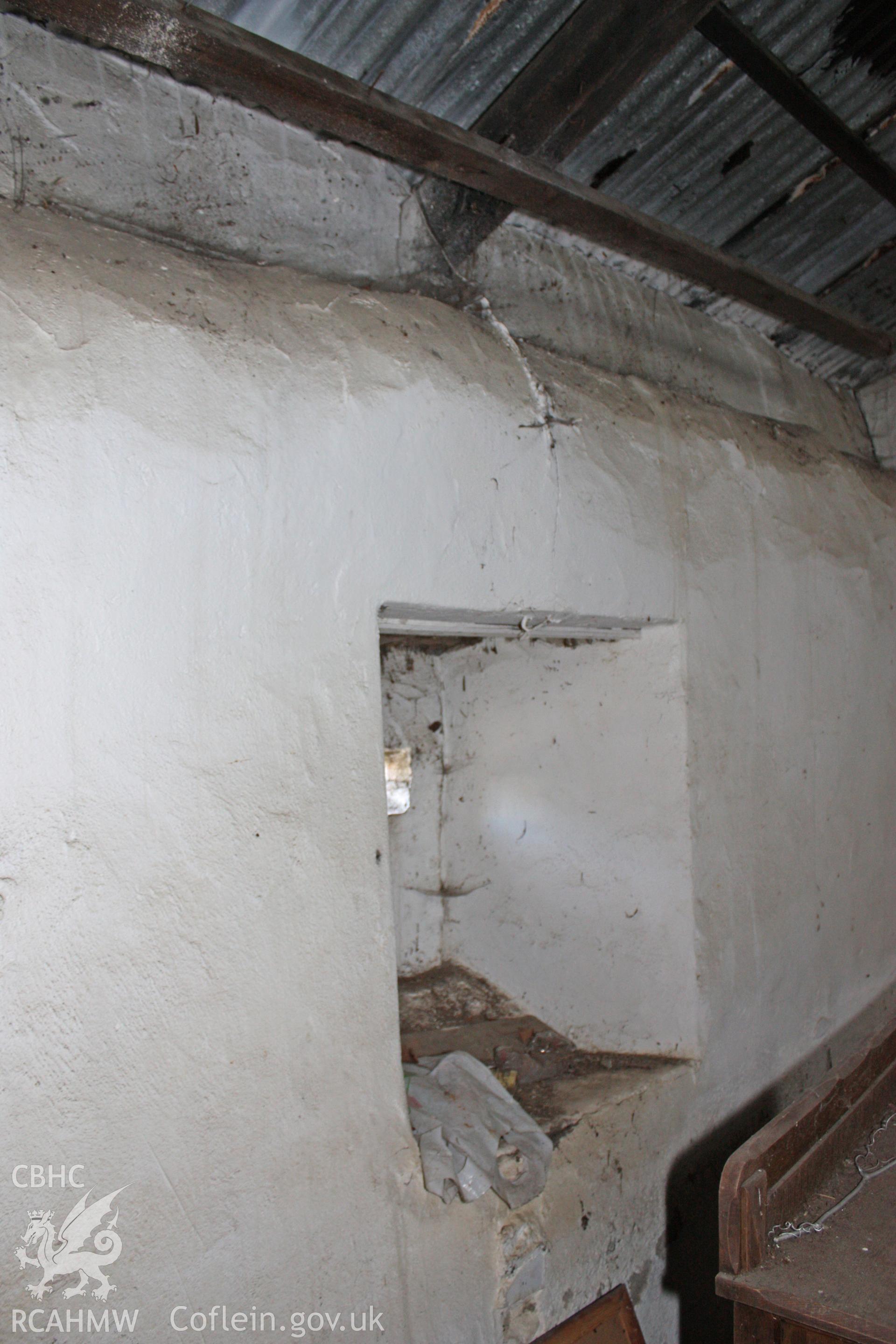 Interior, smithy, south-east wall, showing blocked up window.