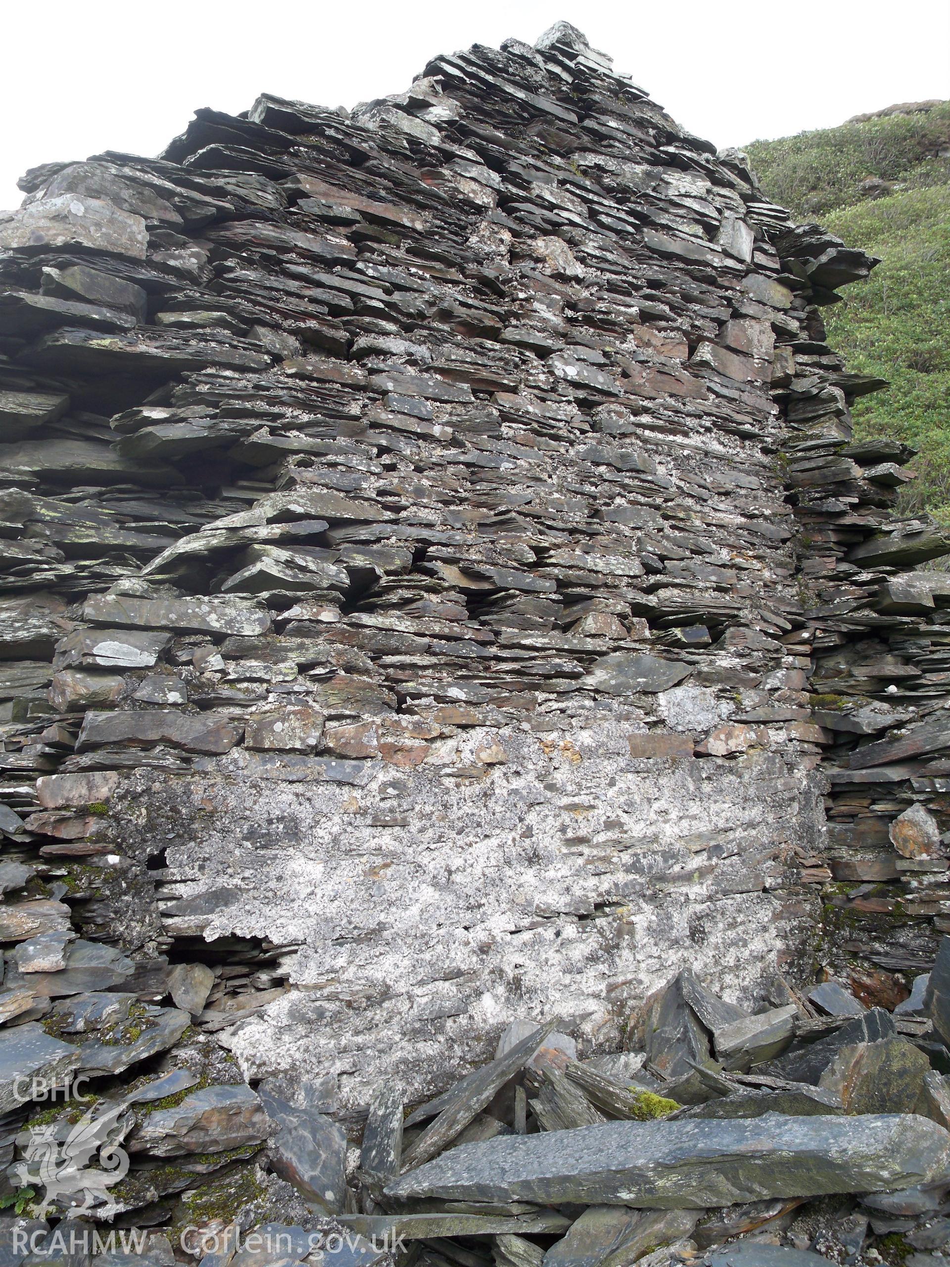 View of the internal face of the western wall of the end (north-west) cottage. The surviving roofline is visible, as is the internal white finish applied to the wall. Halfway up the wall are joist holes.