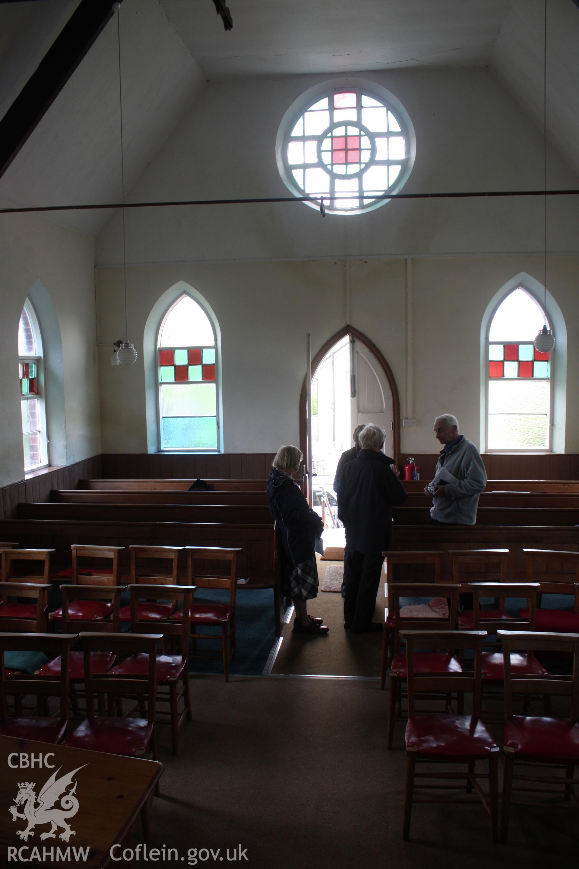Interior, view towards entrance, showing pews & staind glass windows