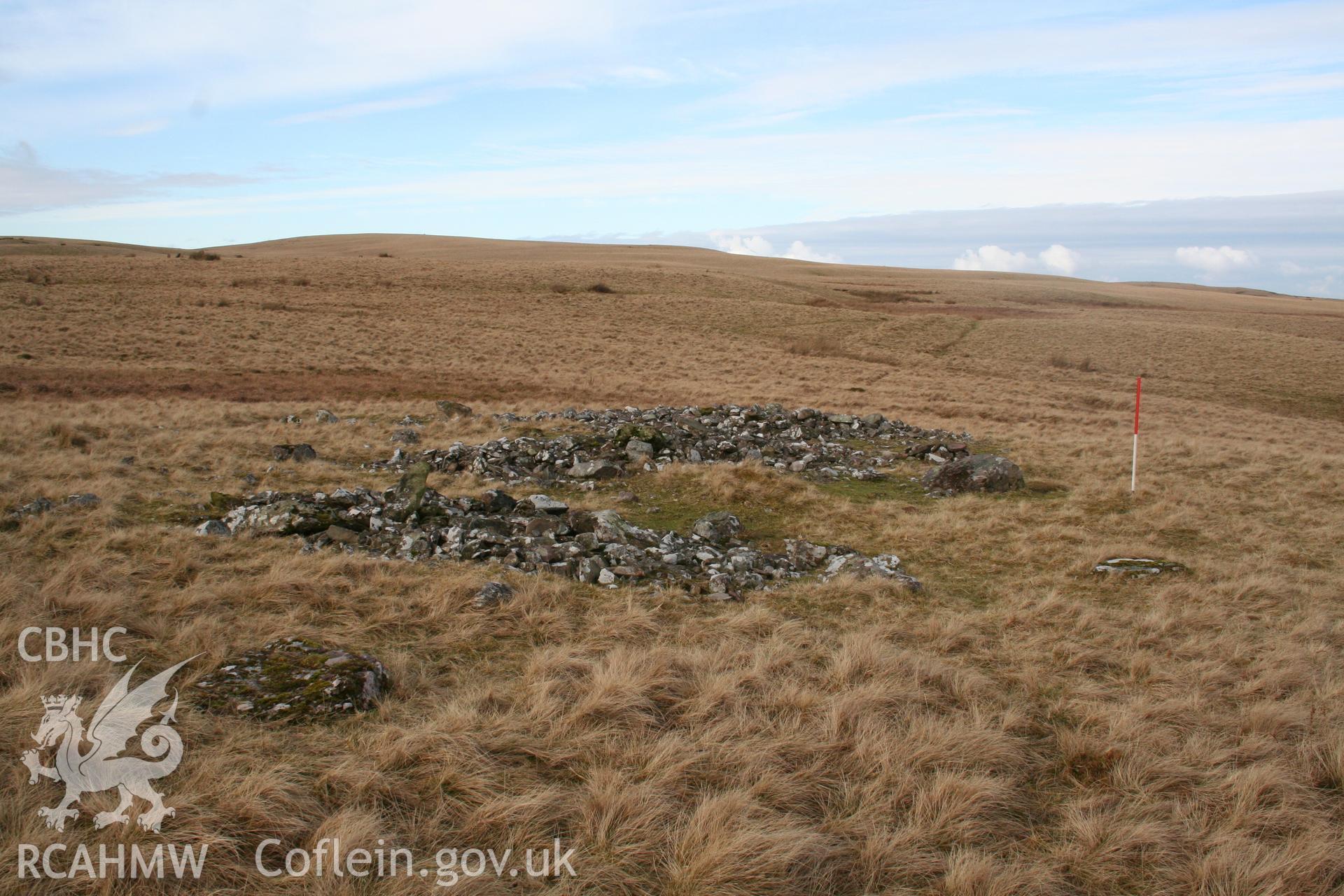 Spread remains of cairn seen from the east; 1m scale.