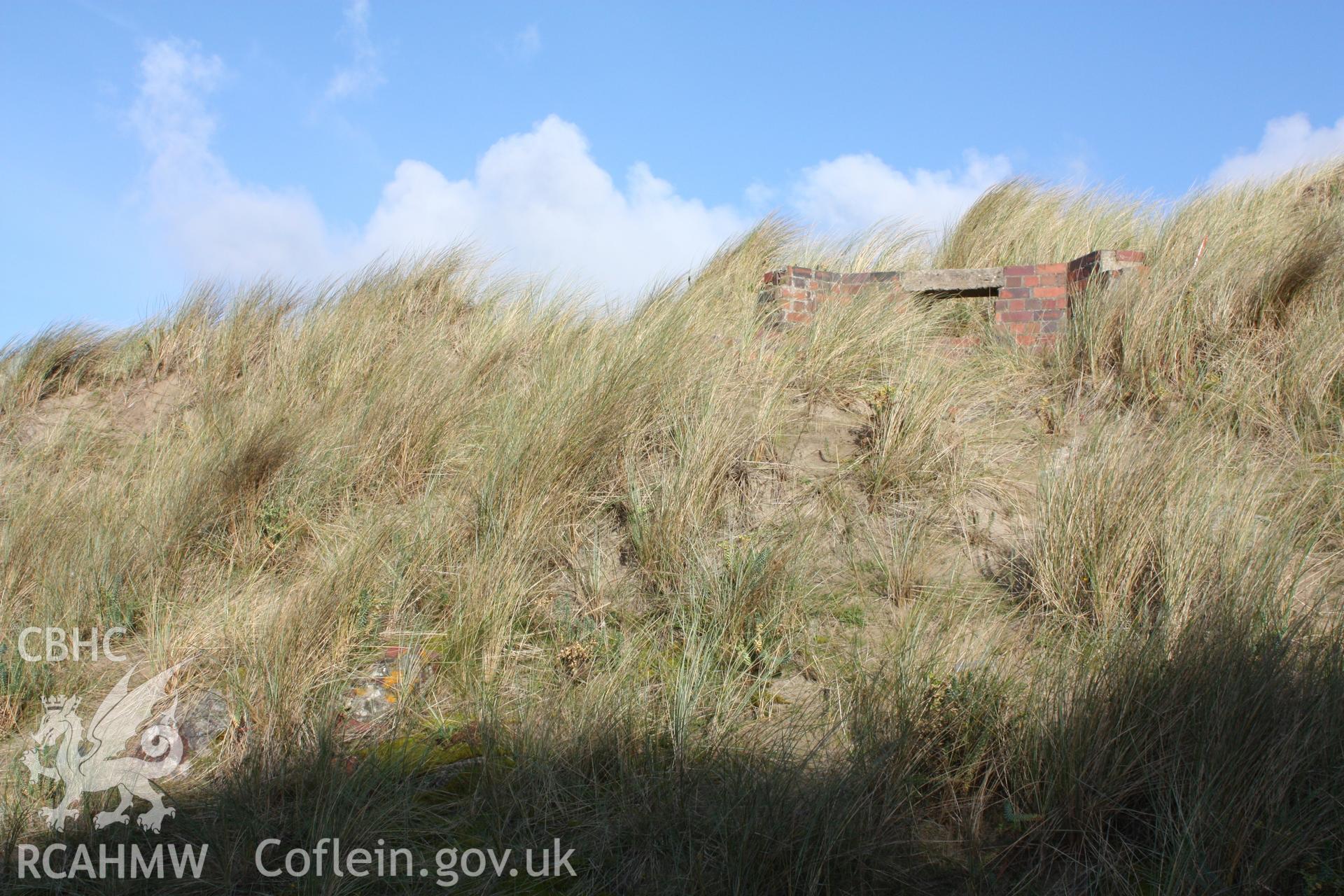 Debris from the demolition of the pillbox (sections of concrete roof ans bricks) scattered down slope to the south