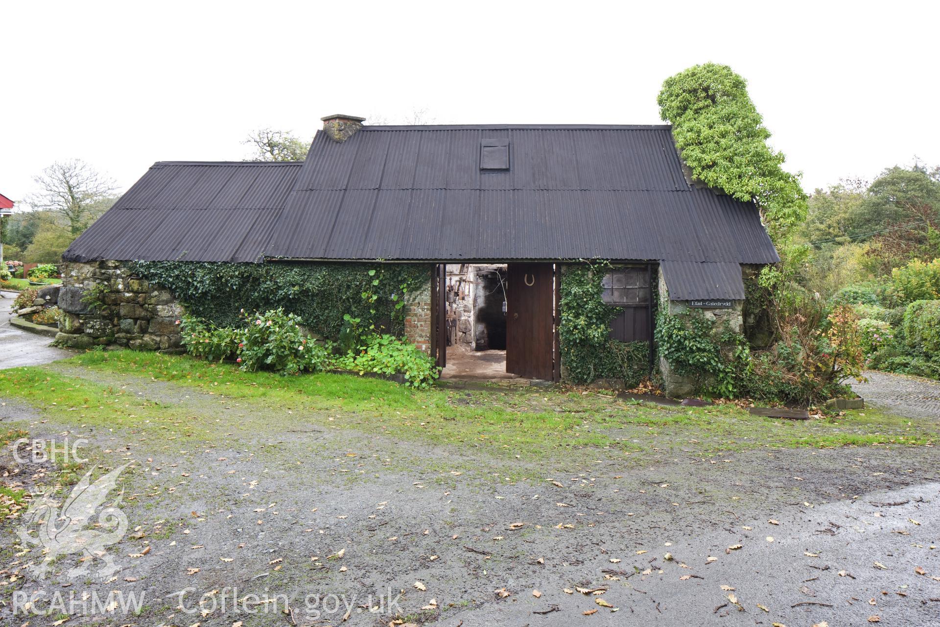 Smithy from the southwest, interior illuminated.