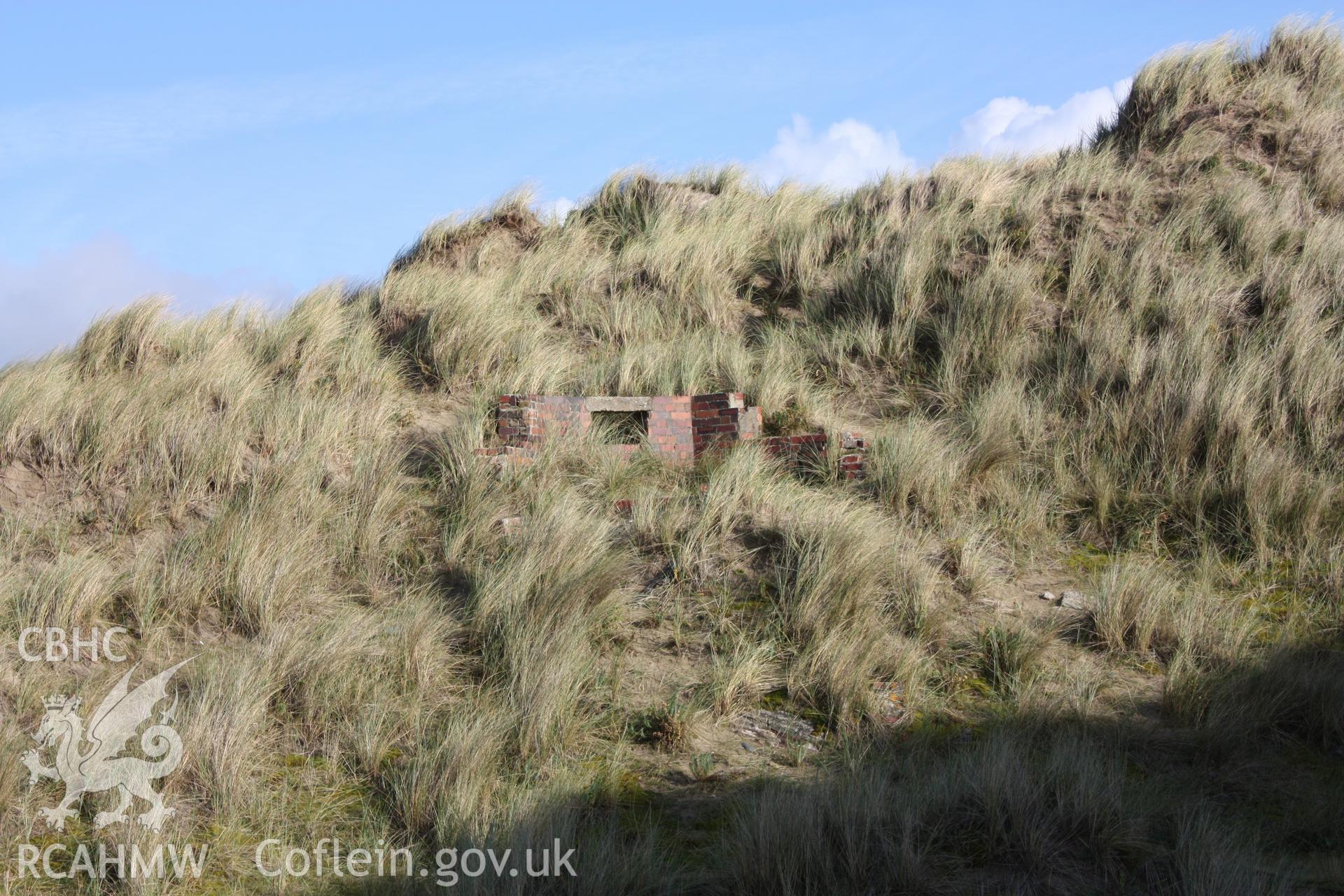 Debris slope beneath pillbox and extant standing remains - observation slit now obscured by sand dune accretion.