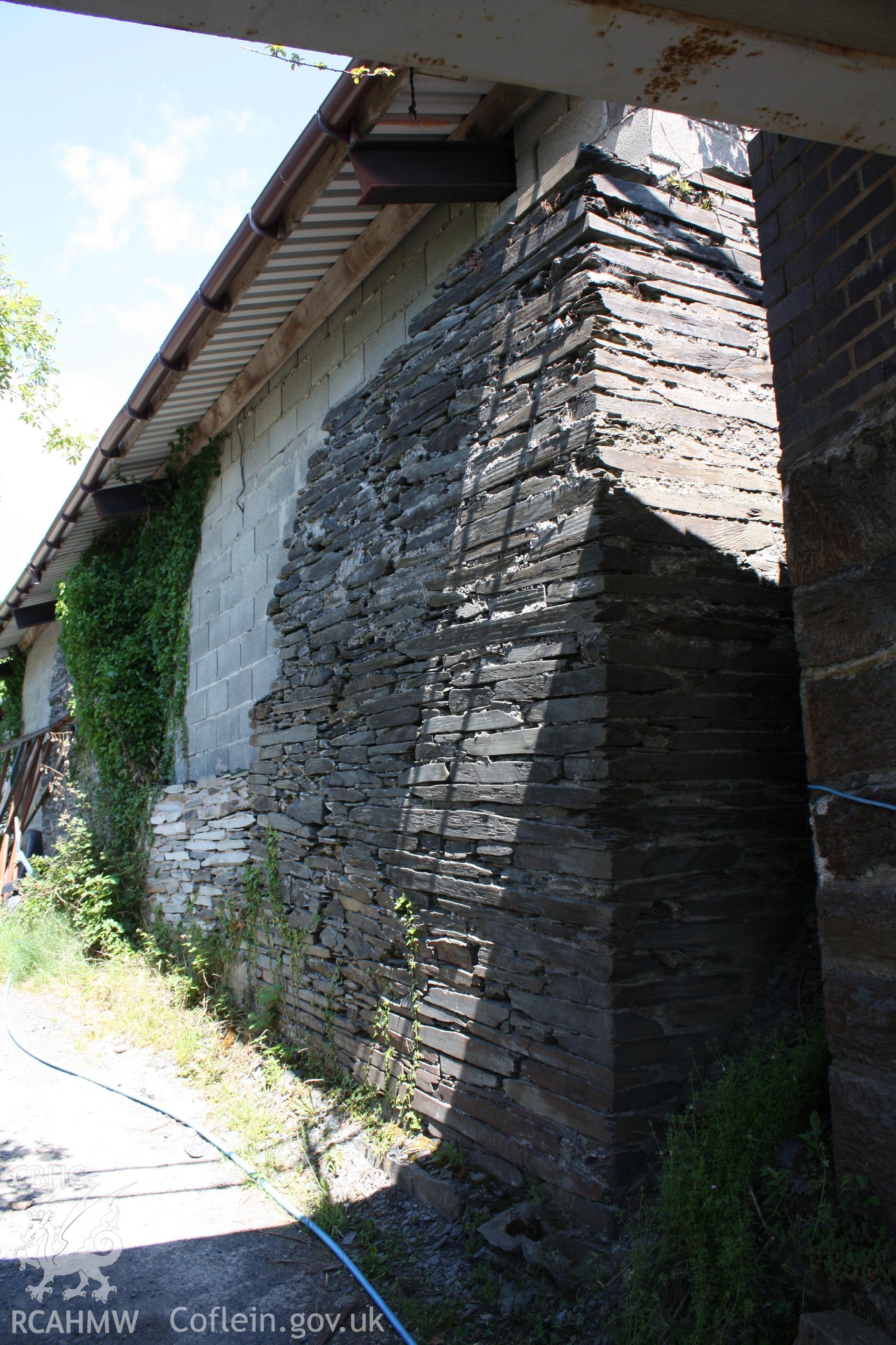 Long western wall of shed partially rebuilt with breeze blocks